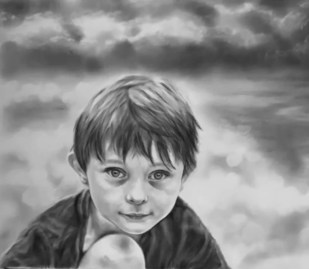 A black-and-white lifelike drawing of a young boy with short brown hair, looking directly at the camera with a slight smile, against a cloudy sky background.
