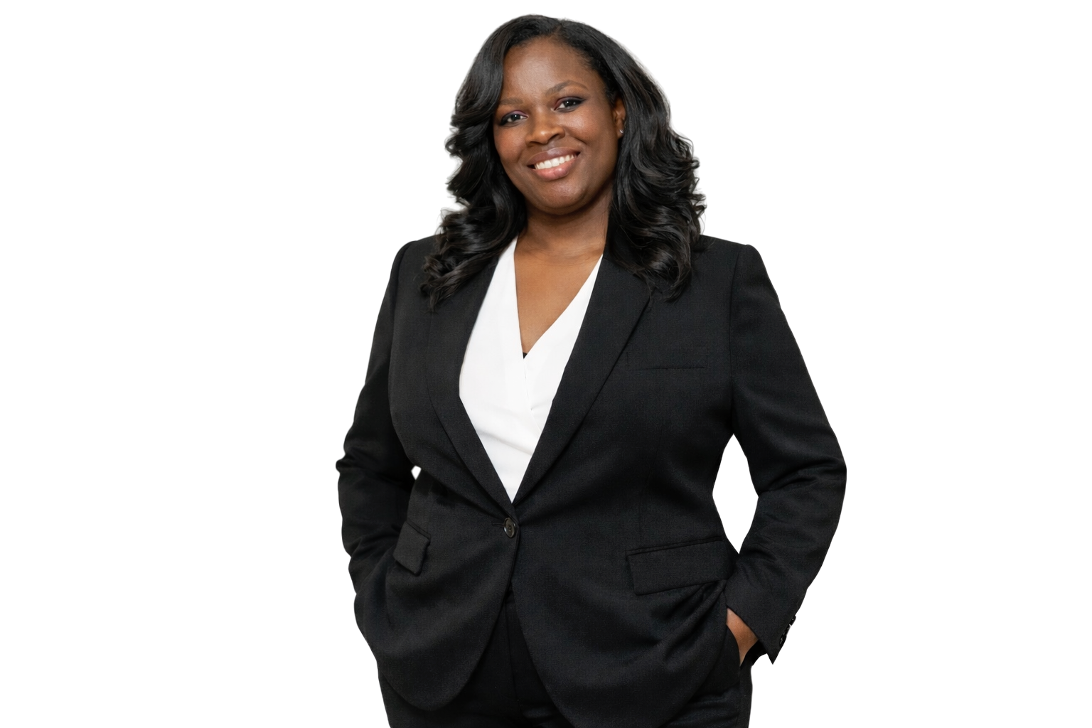 Professional woman with black hair wearing a black blazer and white blouse, standing with her right hand in her pocket, smiling