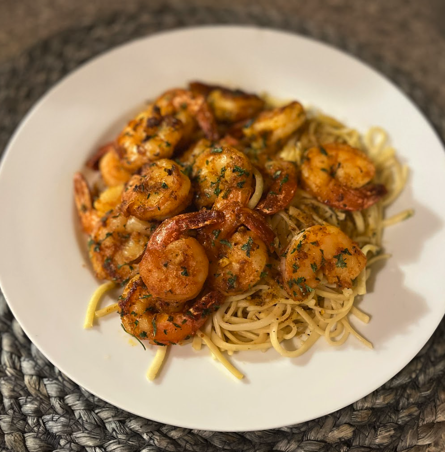 shrimp and pasta dish with herbs on a white plate