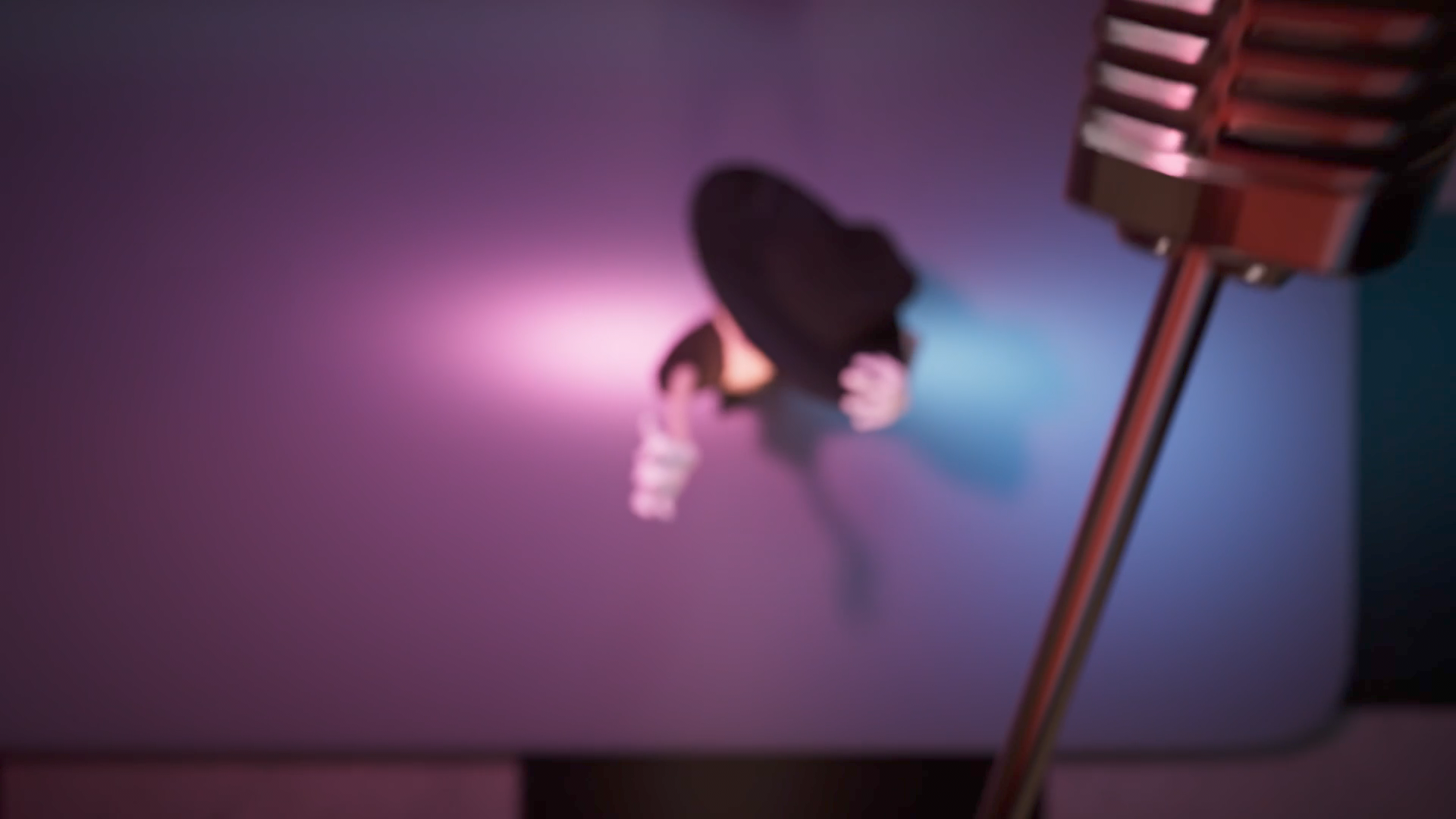 A person is dancing on a colorful stage with a purple and pink gradient background, while a vintage microphone stands in the foreground, out of focus.