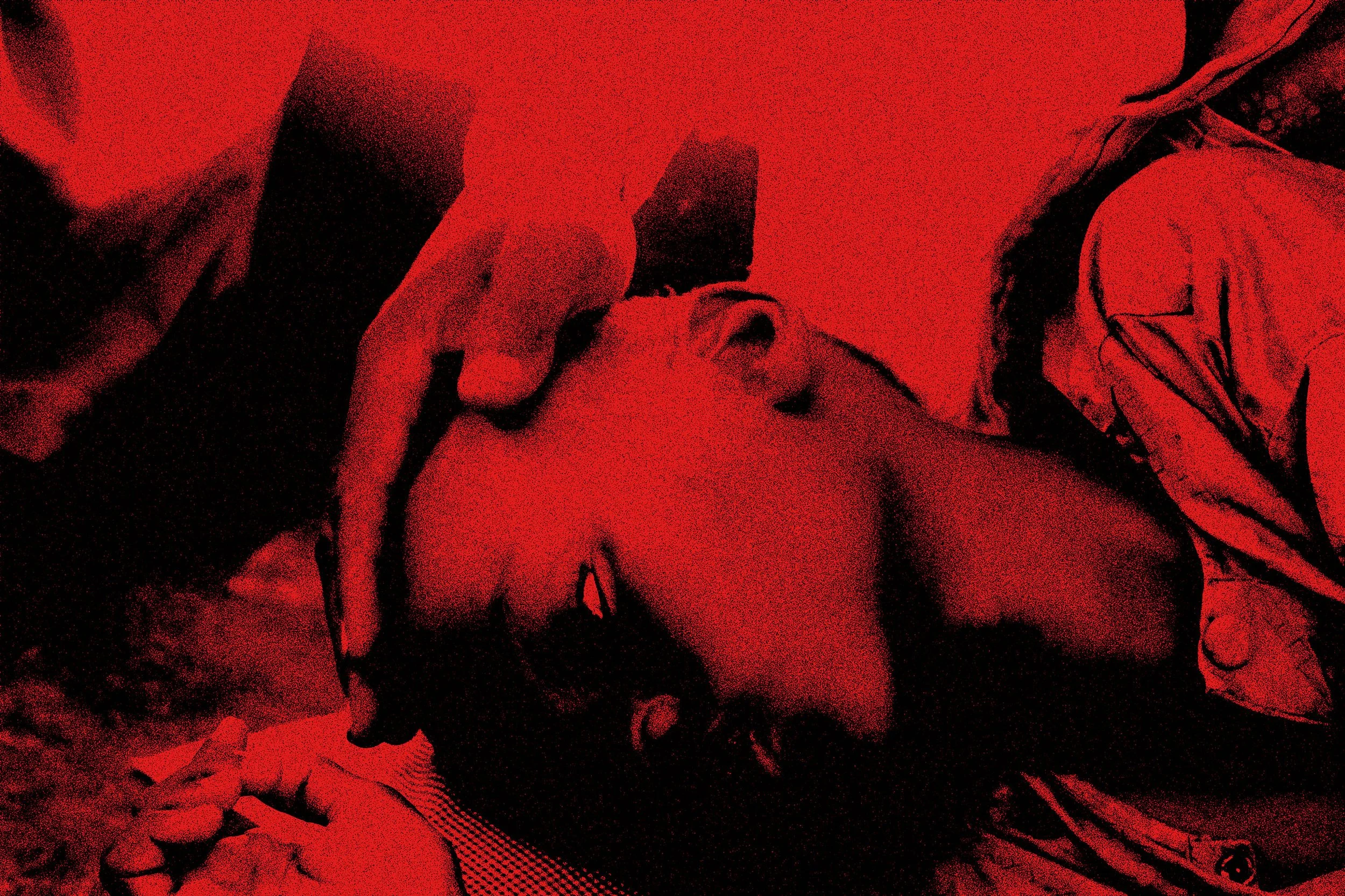 Person lying down with a bandage on their forehead being attended to by another person.