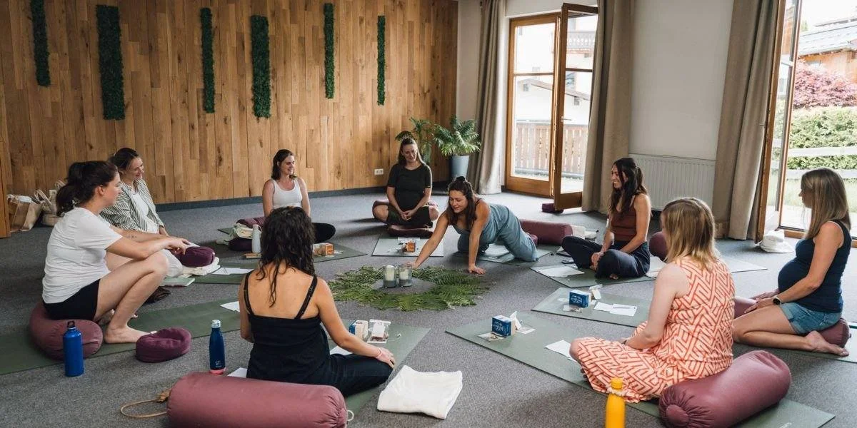 Gruppe im Yoga- und Meditationskurs in einem hellen Raum mit Holzdecke