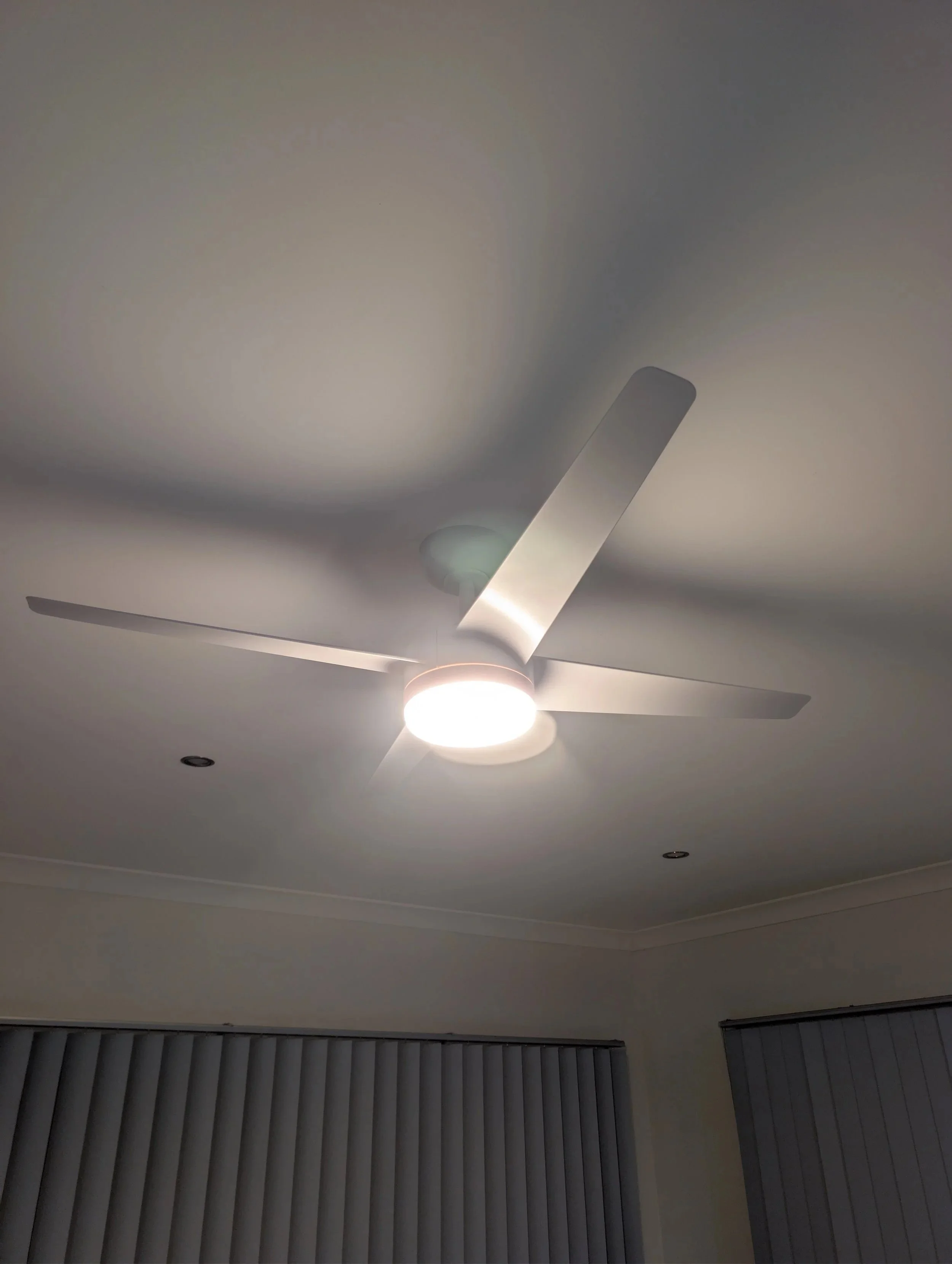 Ceiling fan with three blades and a built-in light fixture, installed on a white ceiling.