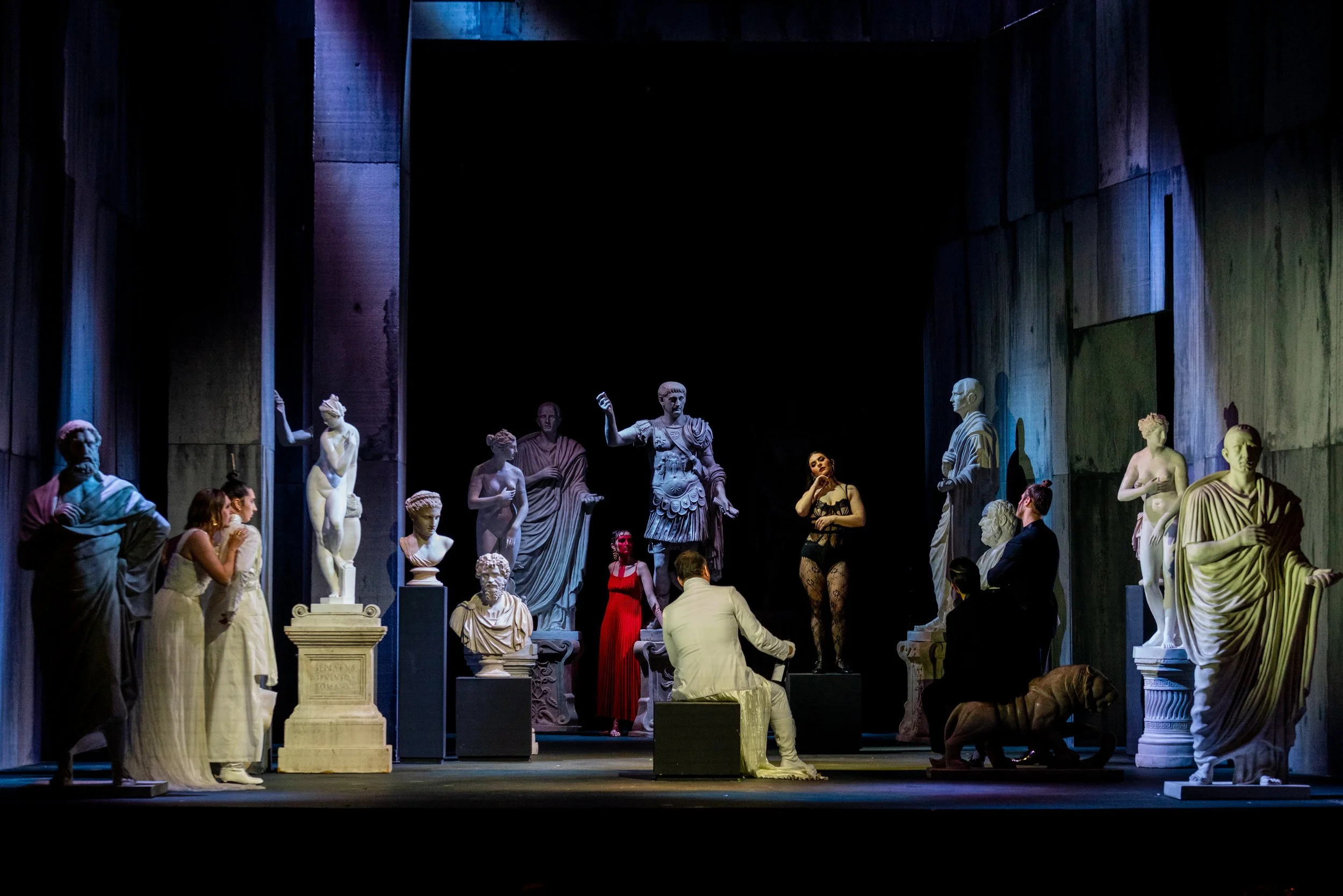 Scene from Abos’ Pelopida at the Valletta Baroque Festival, directed by Brett Nicholas Brown, with performers among classical statues in a museum setting.