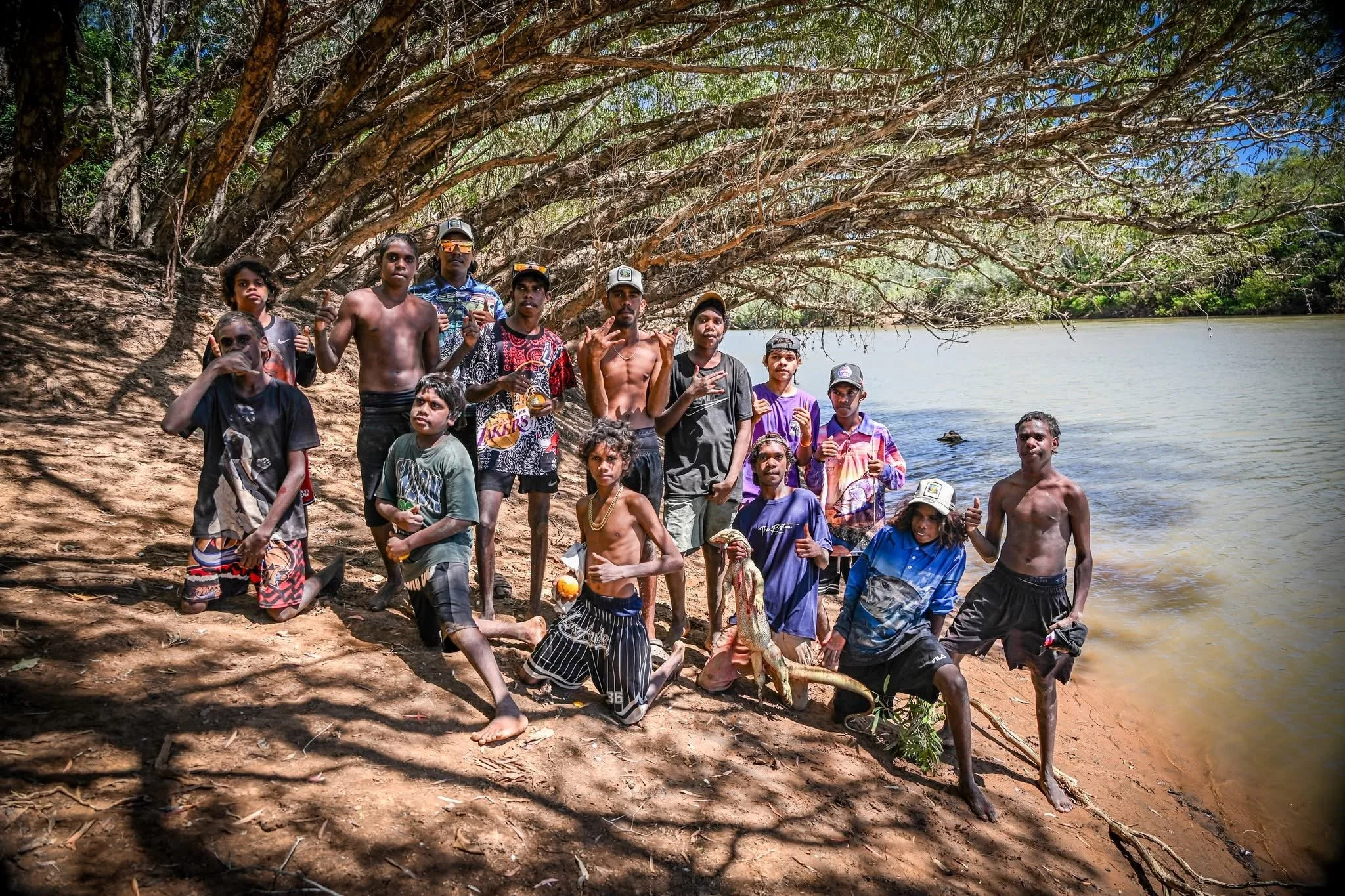 People of all ages posing by a river