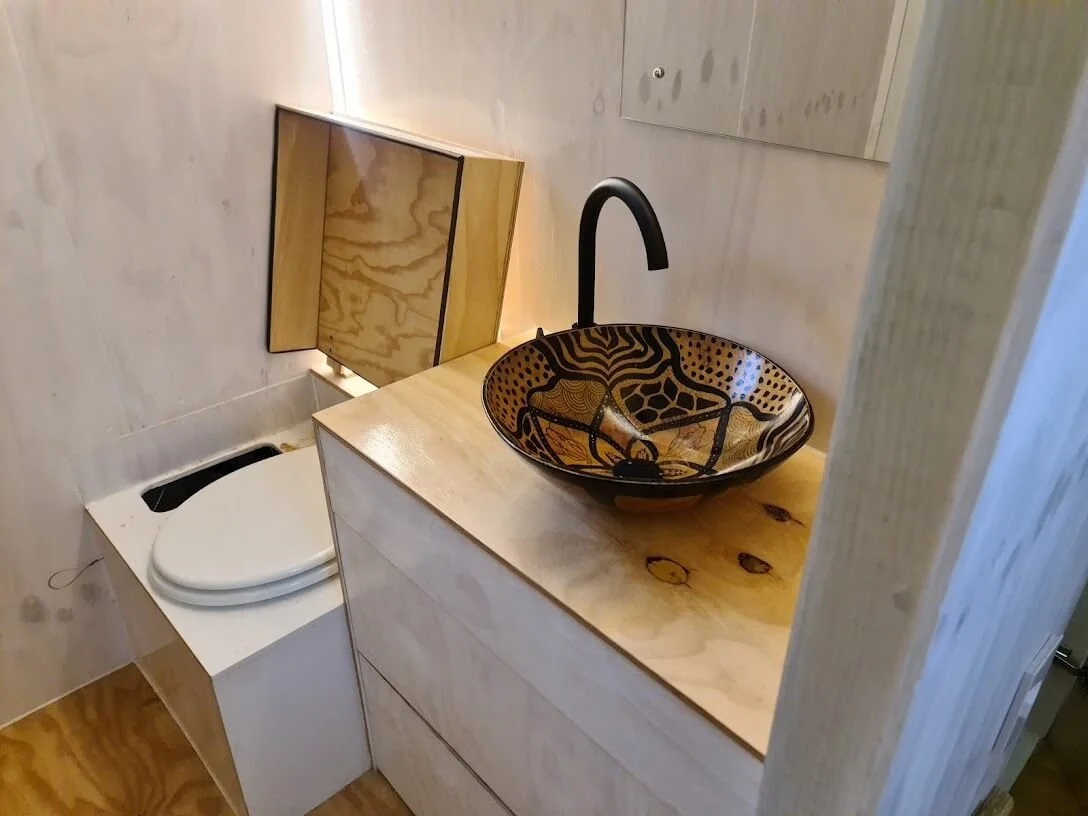 A double shower, basin with two vanity drawers and a composting toilet in this not-so-tiny-bathroom. 