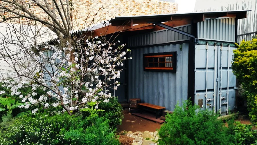 Two, six meter shipping containers become a back yard workshop. Various sizes reclaimed I-beams welded to the top of the containers, receives the roof. Storage space above is immense.