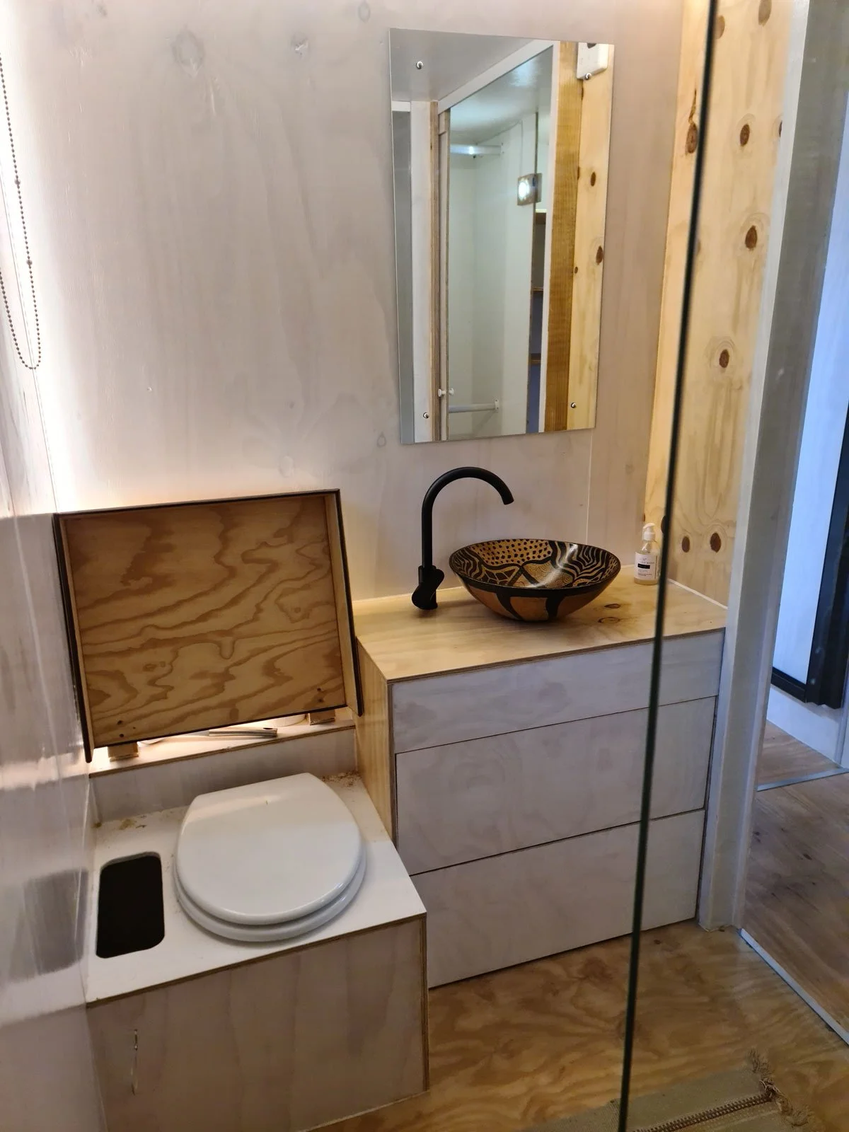 A double shower, basin with two vanity drawers and a composting toilet in this not-so-tiny-bathroom. 