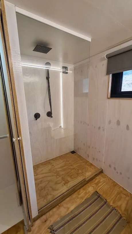 More cupboard space for clothes in the passage which serves as a dressing room adjacent to the tiny house bathroom.