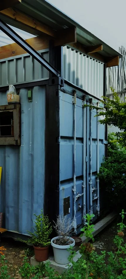 Two, six meter shipping containers become a back yard workshop

Various sizes reclaimed I-beams welded to the top of the containers, receives the roof

Storage space above is immense
