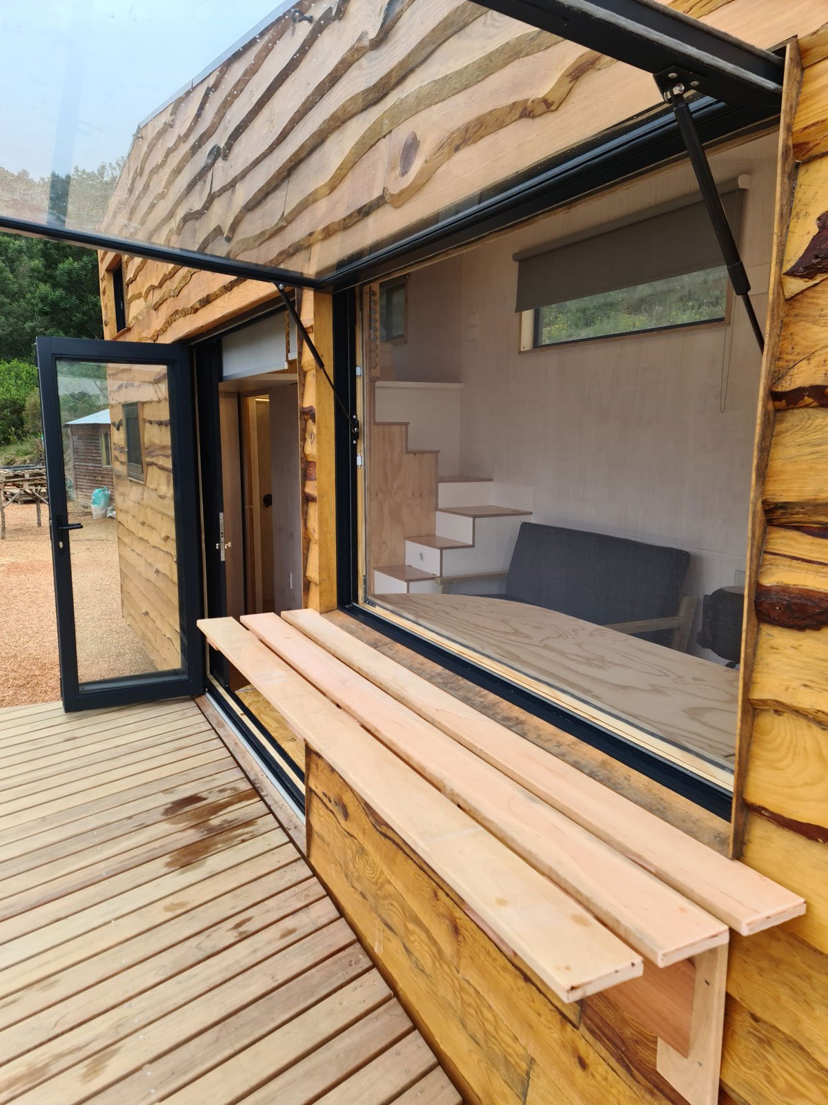 The staircase serves for loads of utility space and houses the laundry accessible from the outside of the CaveLet tiny house.

The inside-out bar counter lives out onto a 50 square meter hardwood deck and flips down on the inside the tiny house for s
