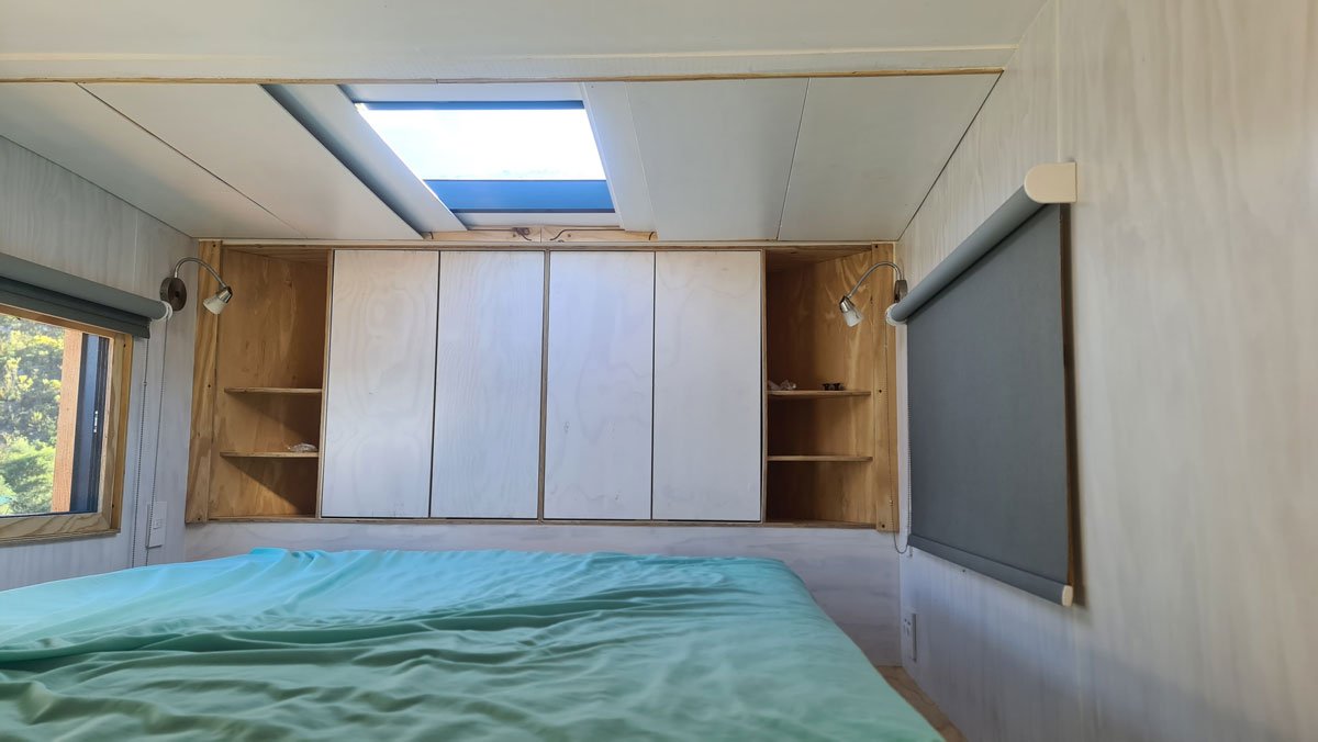The top of the staircase is adorned with a custom hexagonal design privacy screen and roof shutters slide open to reveal the skylight for some stargazing in bed.

Even more shelved cupboard space with built in bedside tables at the head of the bed, c
