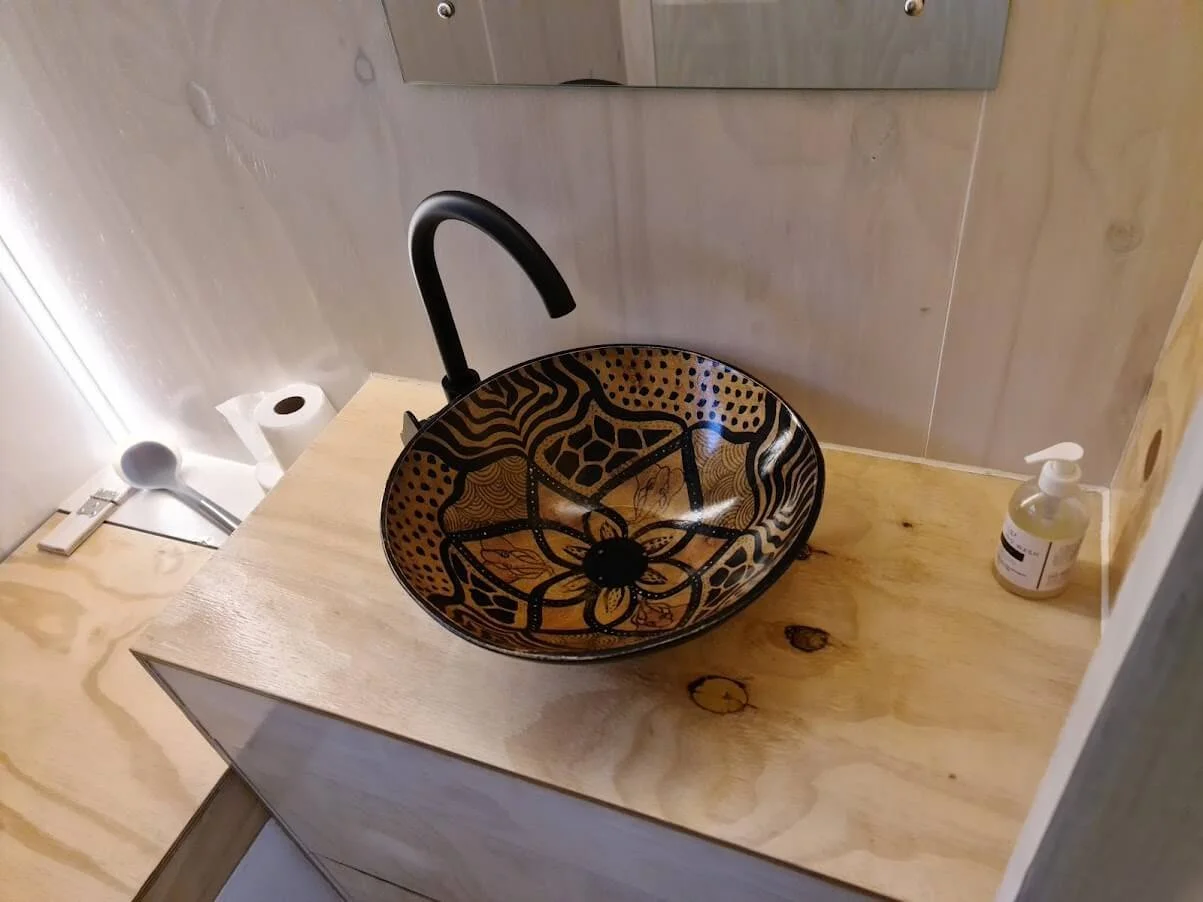 A double shower, basin with two vanity drawers and a composting toilet in this not-so-tiny-bathroom. 
