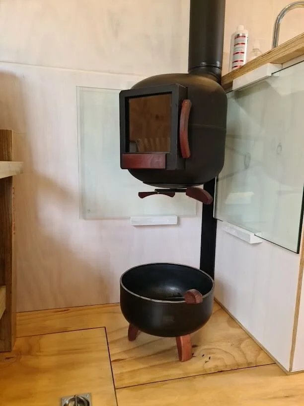 The little black fireplace packs a punch, made from an old 9kg gas bottle and finished with Jarrah hardwood details...a matching wood storage basket under.