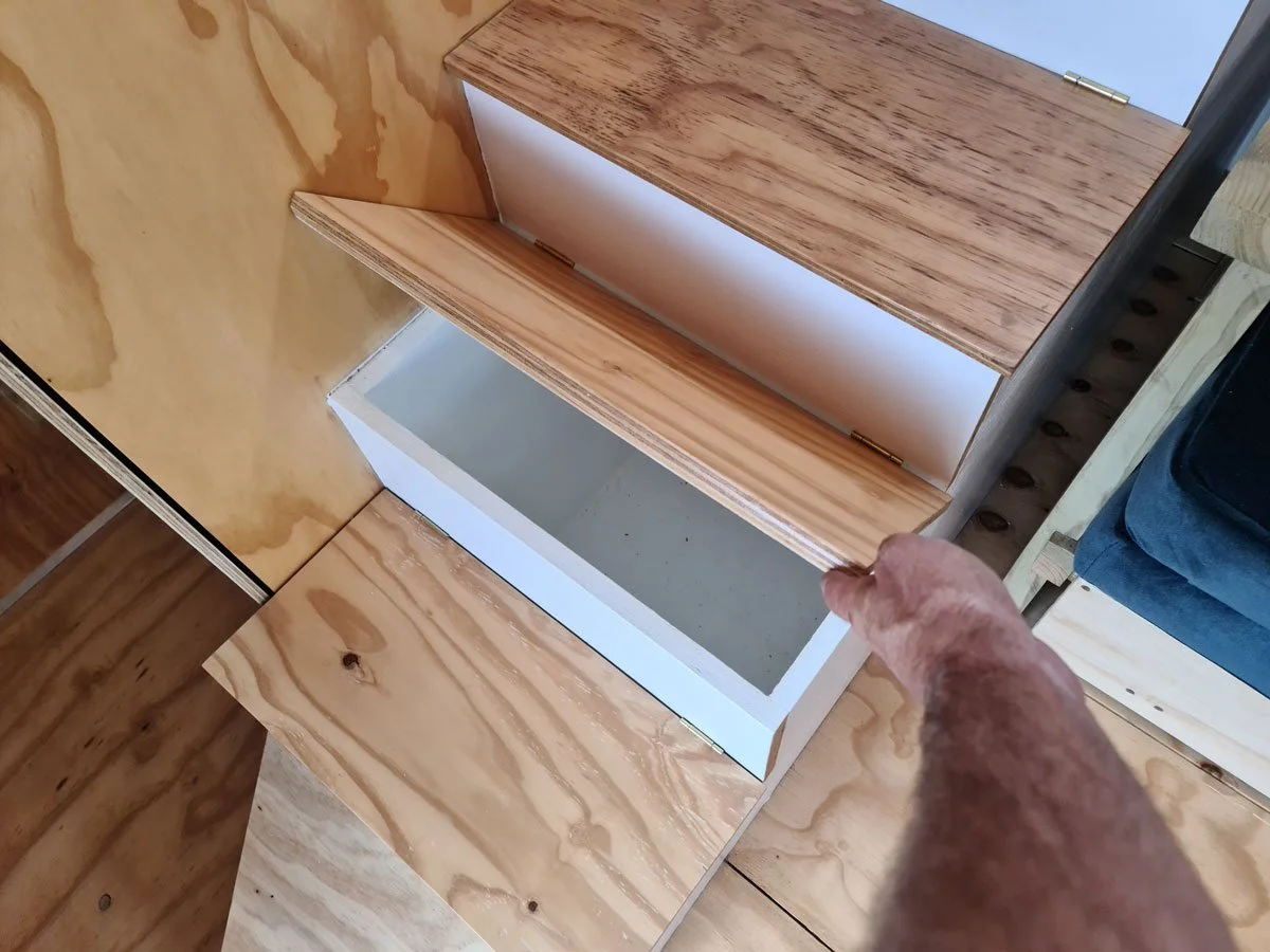 The staircase serves for loads of utility space and houses the laundry accessible from the outside of the CaveLet tiny house. The inside-out bar counter lives out onto a 50 square meter hardwood deck and flips down on the inside the tiny house for s