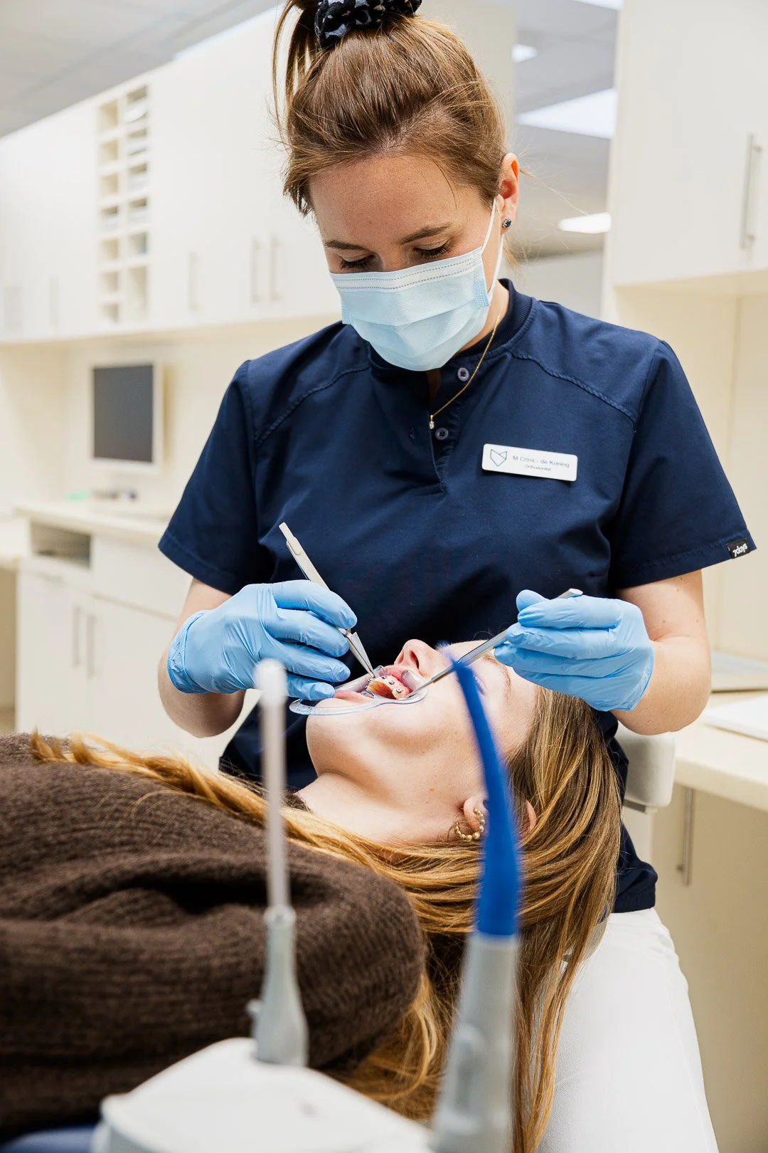 Dentist or oral surgeon performing a dental procedure on a patient in a dental office.