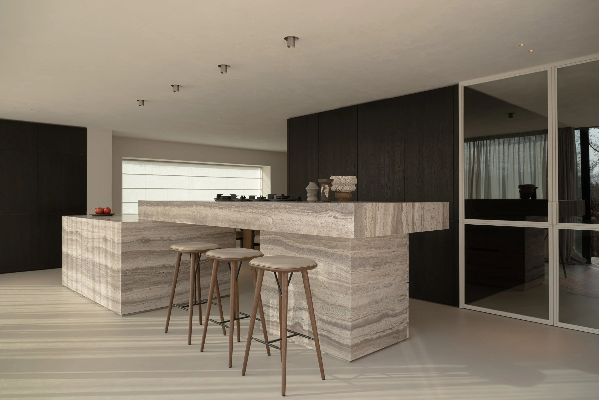 Modern kitchen with a marble island, dark wood cabinetry, and a large window with blinds.