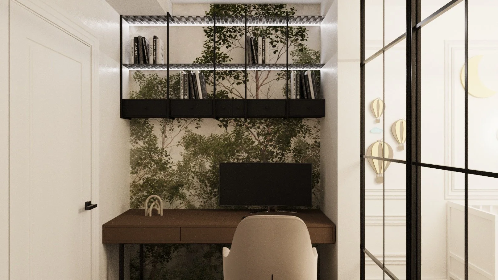 A small home office with a dark wooden desk, a beige chair, a computer monitor, and decorative items. A wall with green leaf wallpaper and black wall shelving holding books is visible. Part of a glass partition with black framing and a white wall wit