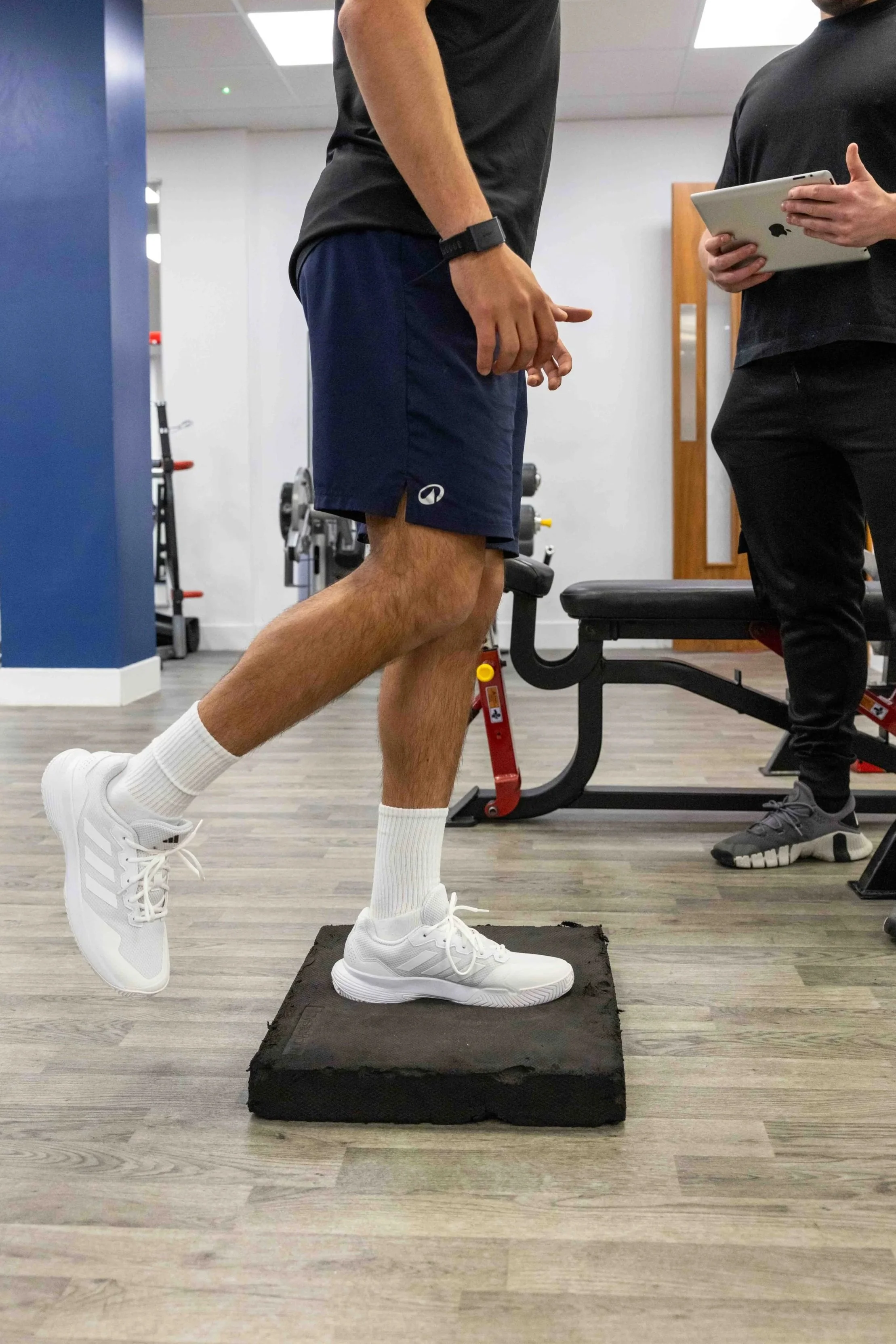 Client performing a single-leg balance exercise on a foam pad during a rehabilitation session at NRG Sports Therapy in Bloomsbury.