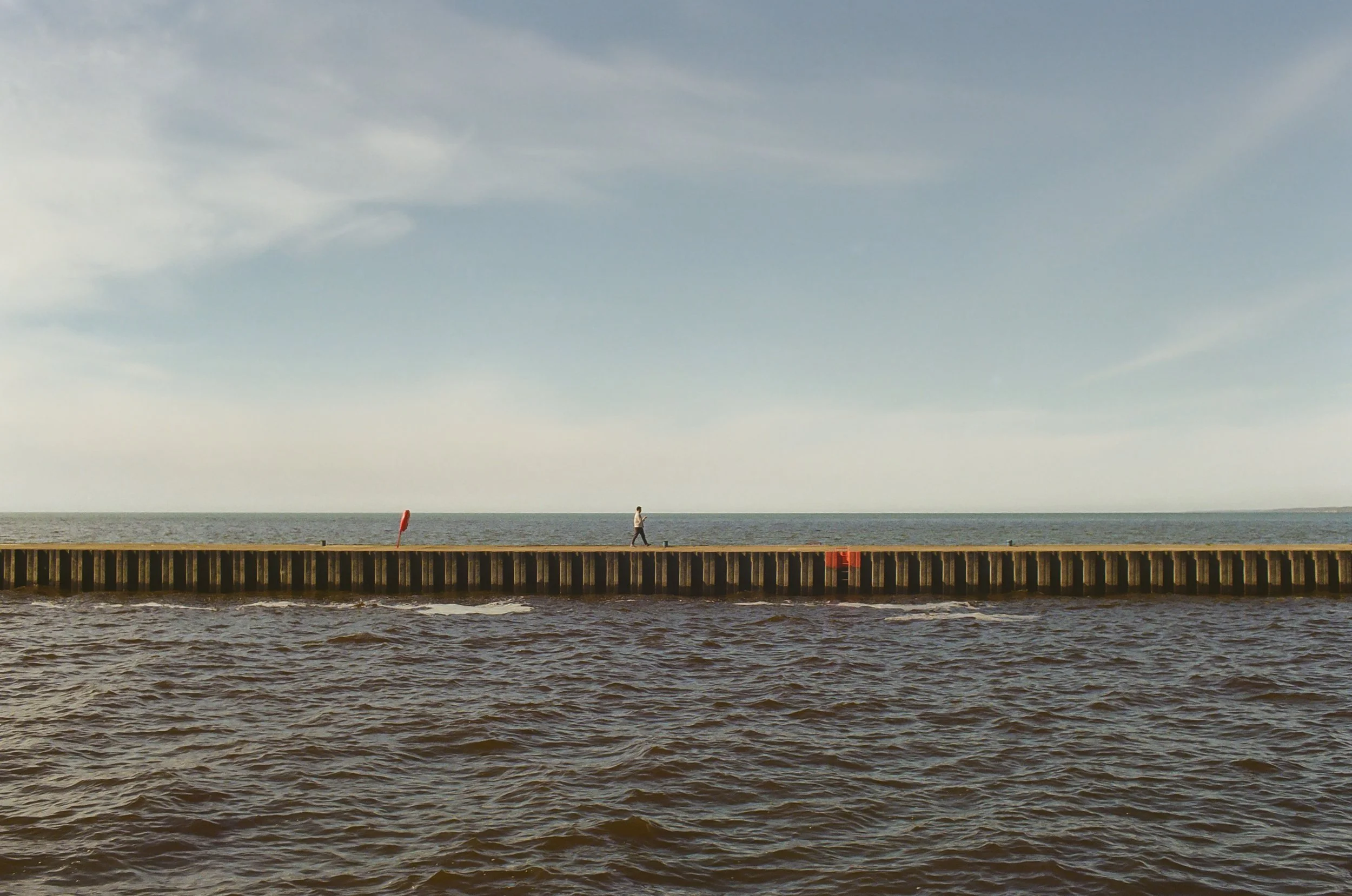 south_haven_a tiny man walks the pier.jpg
