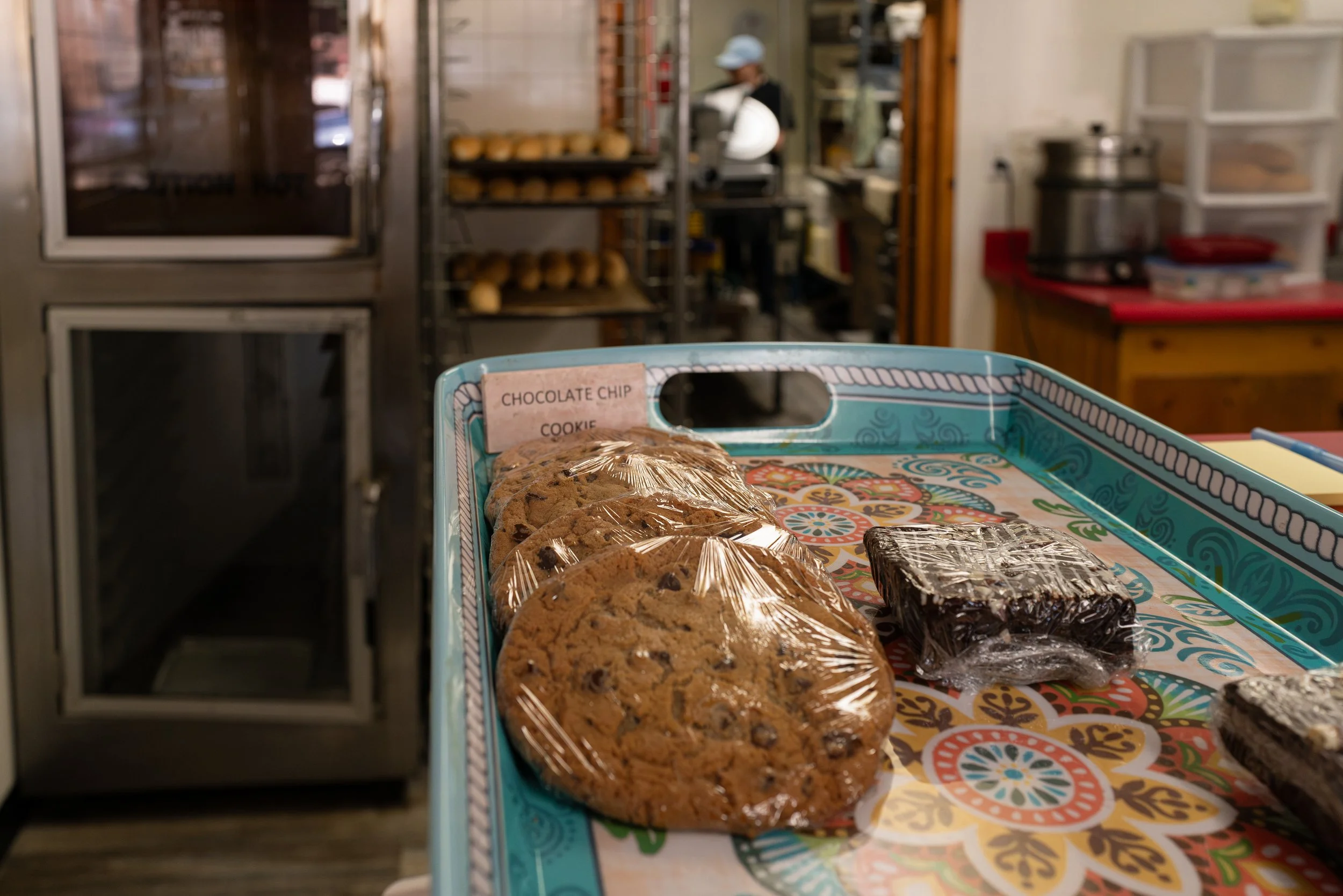 Tray of cookies including chocolate chip and possibly oatmeal in a bakery kitchen.