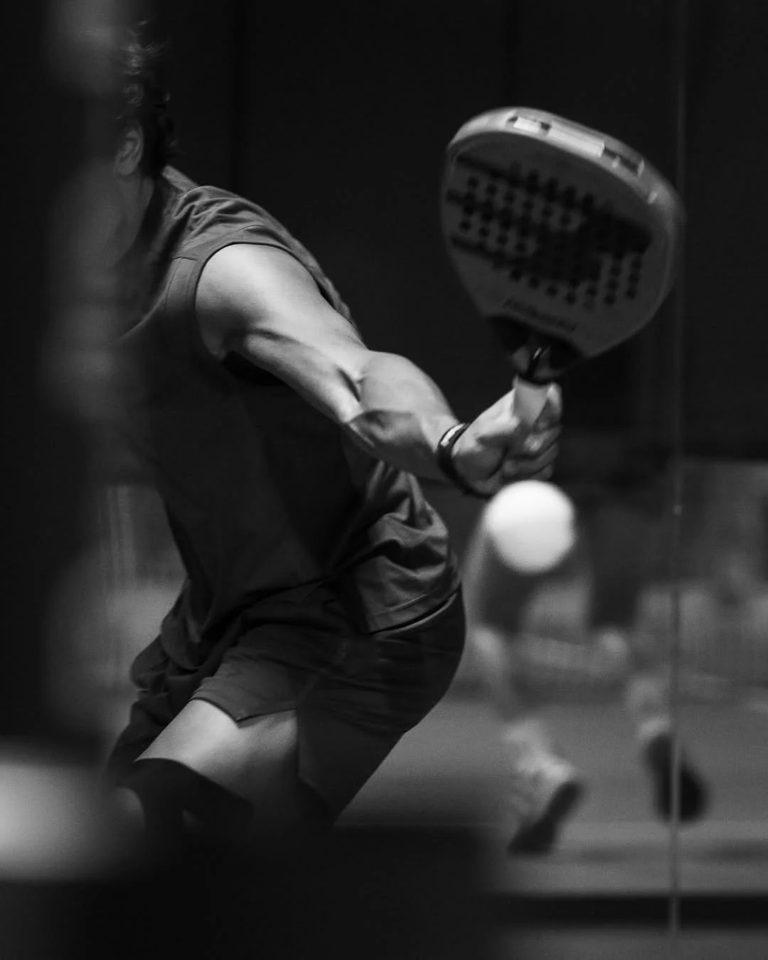 A person playing pickleball, preparing to hit a ball with a paddle.