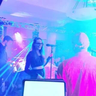 Kay from Sing with Kay performing center stage as lead singer with 8-piece band, including vocalist Corey Woseley, for 600 people