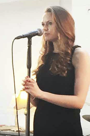Kay from Sing with Kay performing solo in front of a microphone for a music video, showcasing singing and vocal performance
