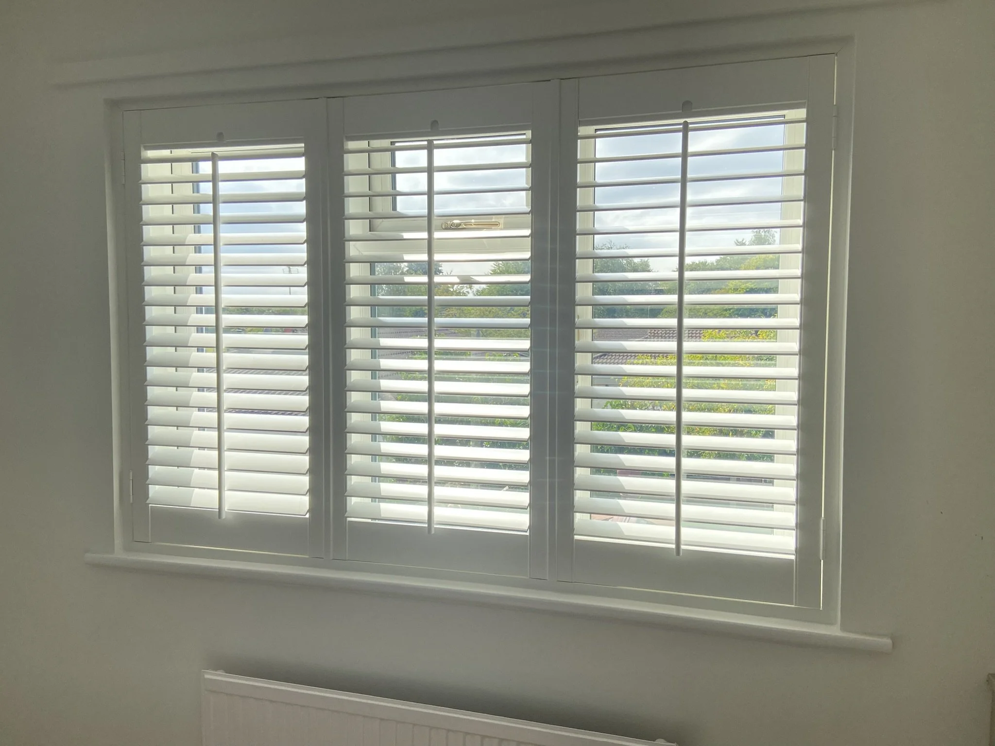 Shutters with centre tilt bar fitted in a window in Croft