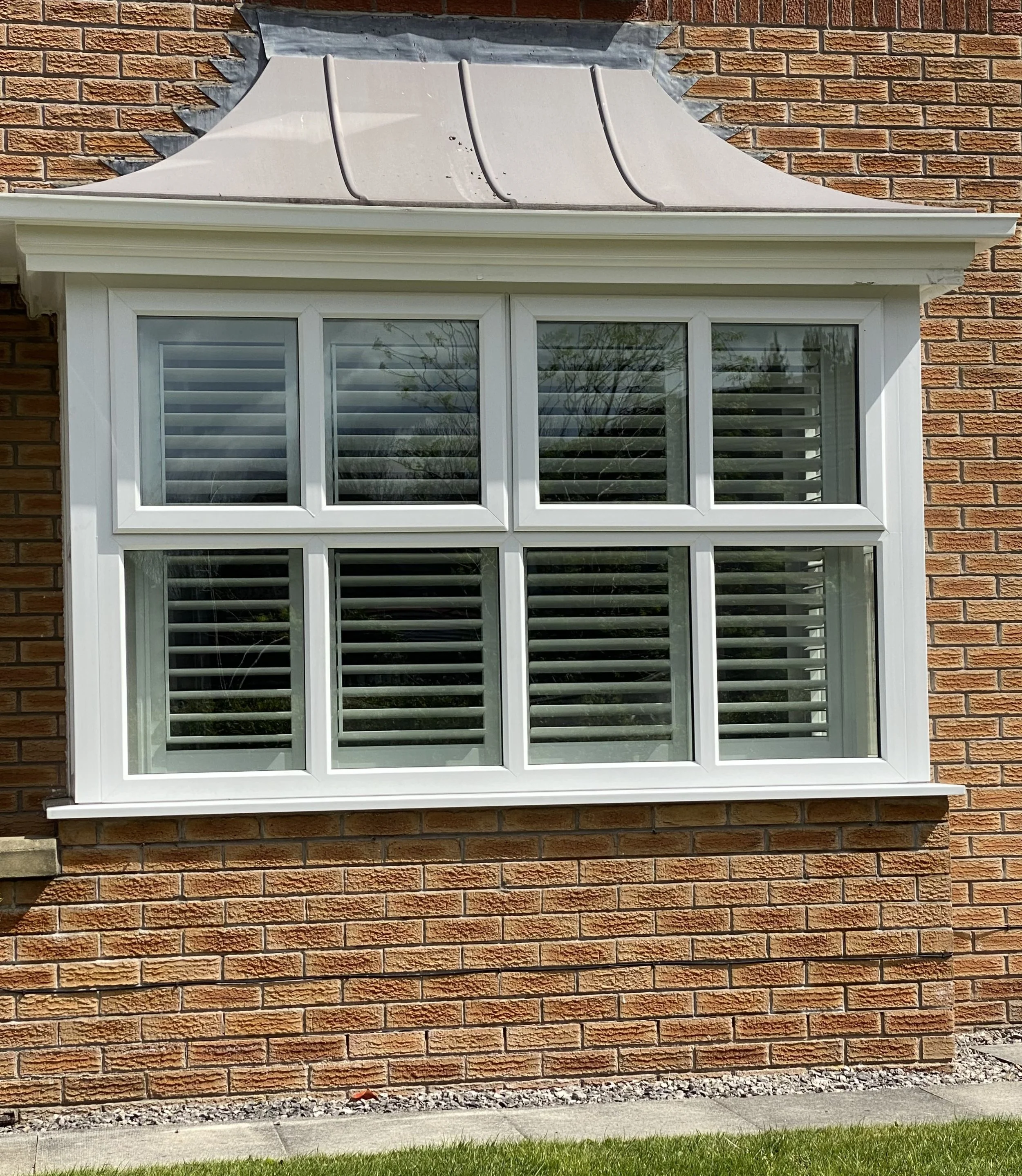 UK-made Shutters fitted to a bay window in Atherton from the outside