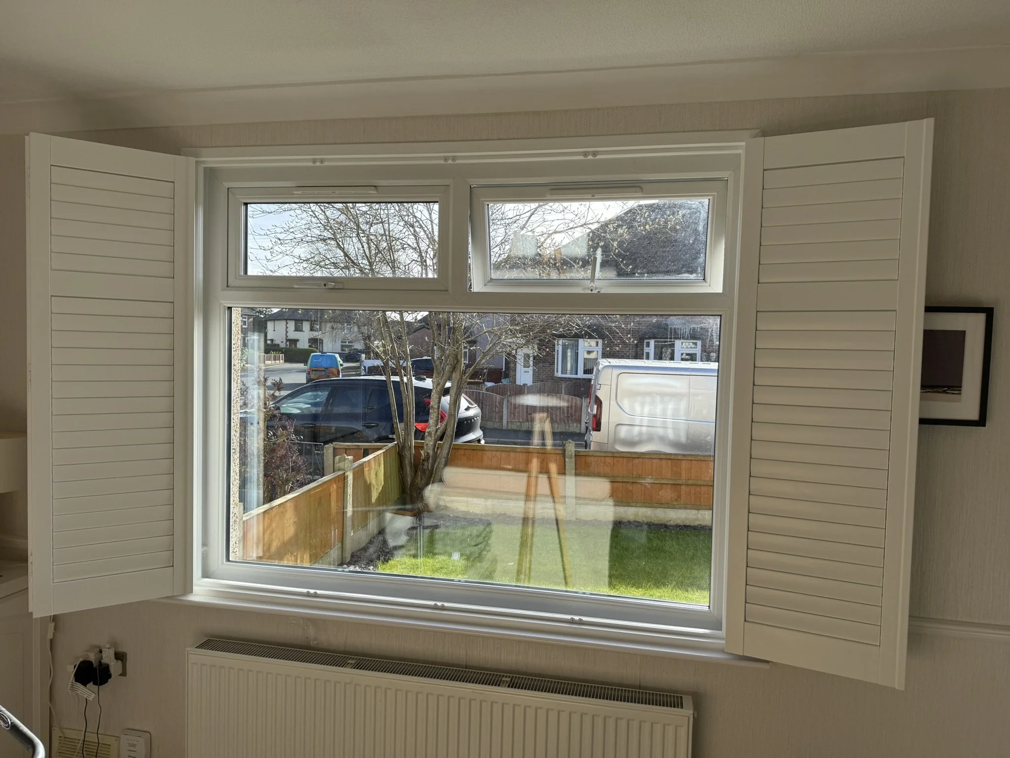 Wooden Shutters open fitted to a large window in Golborne