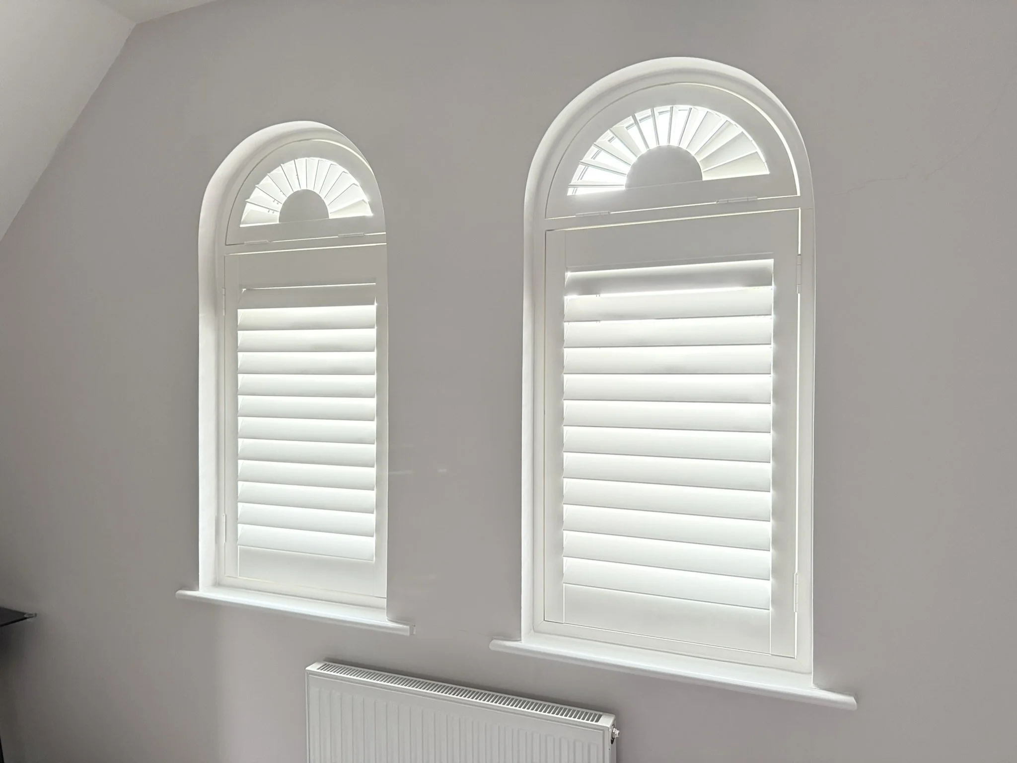 Arch shaped shutters fitted to windows in Lymm
