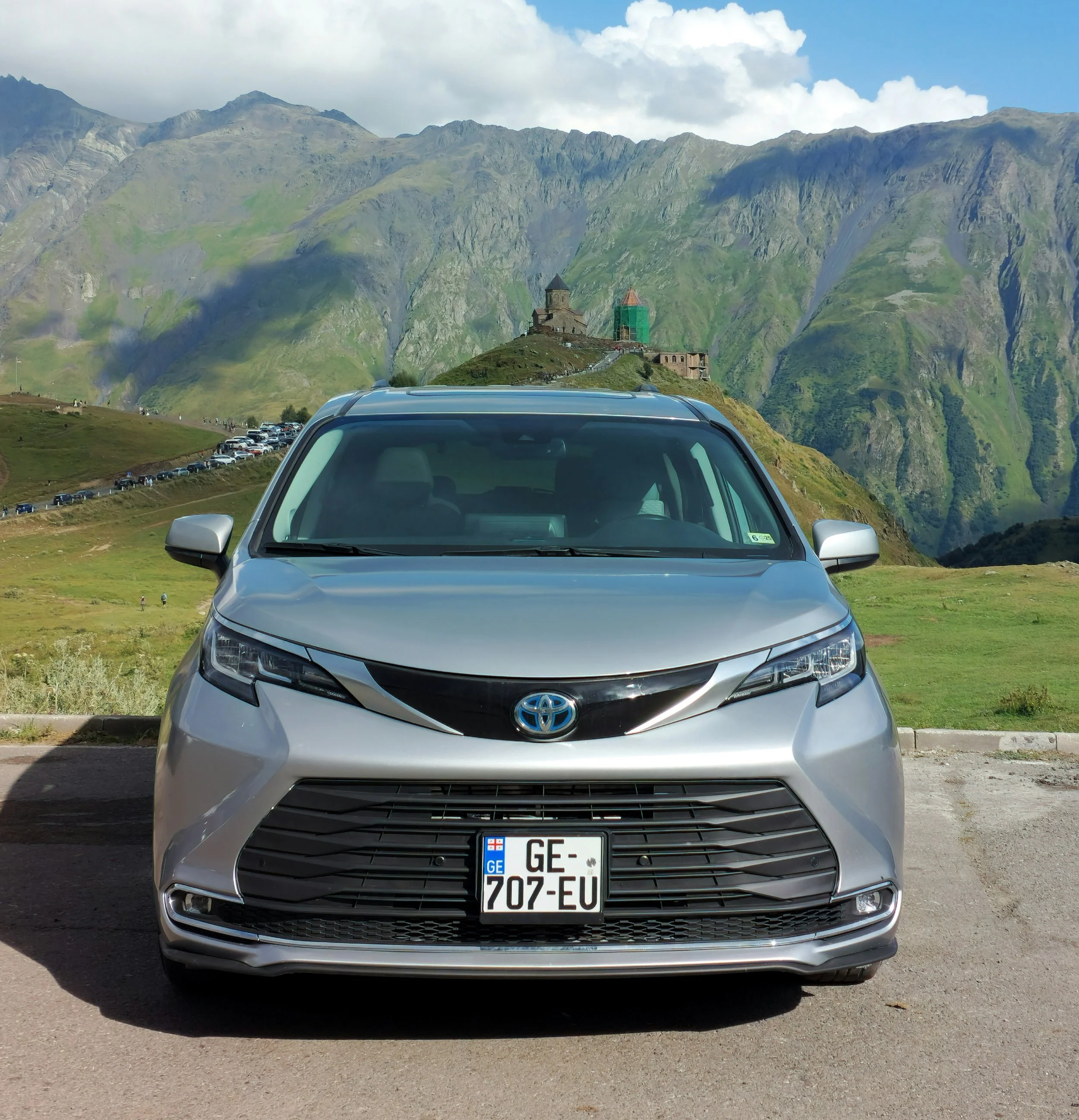Premium private tours in Georgia: Our 2021 Toyota Sienna Hybrid minivan parked near a historic mountain church.