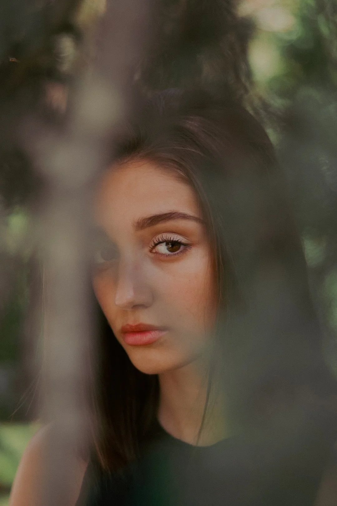 Portrait d'une jeune femme aux cheveux bruns, yeux clairs, portrait artistique avec un flou artistique