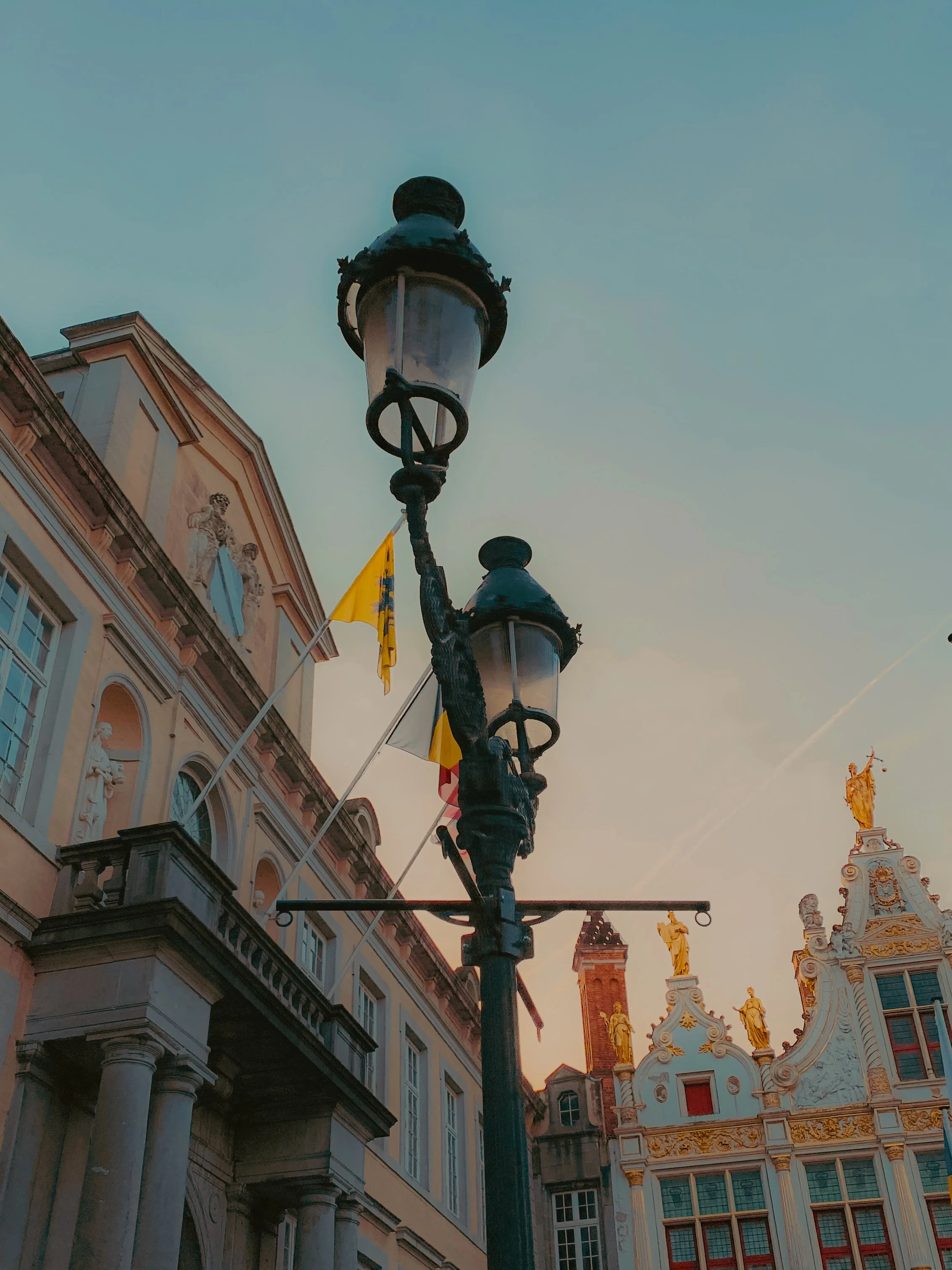 Un lampadaire dans une rue avec des bâtiments historiques en arrière-plan.