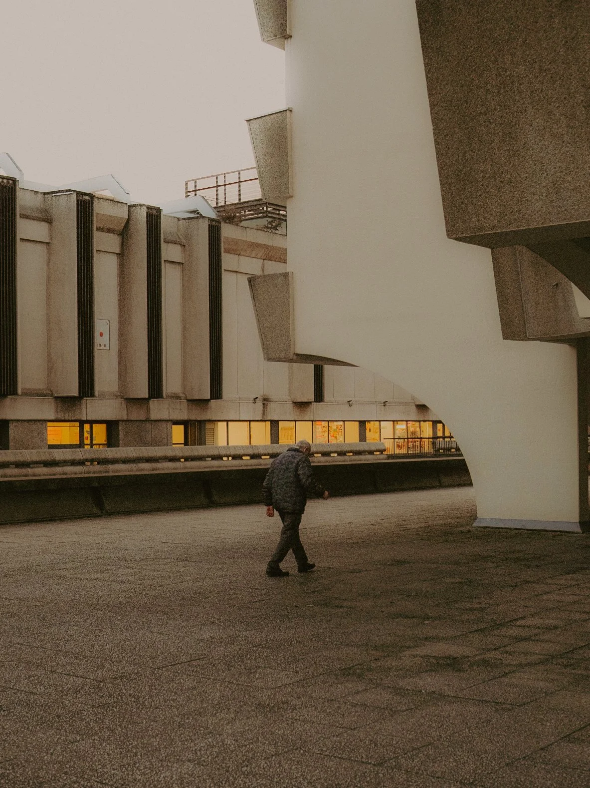 Une personne marchant sous un bâtiment moderne et architectural dans une ville