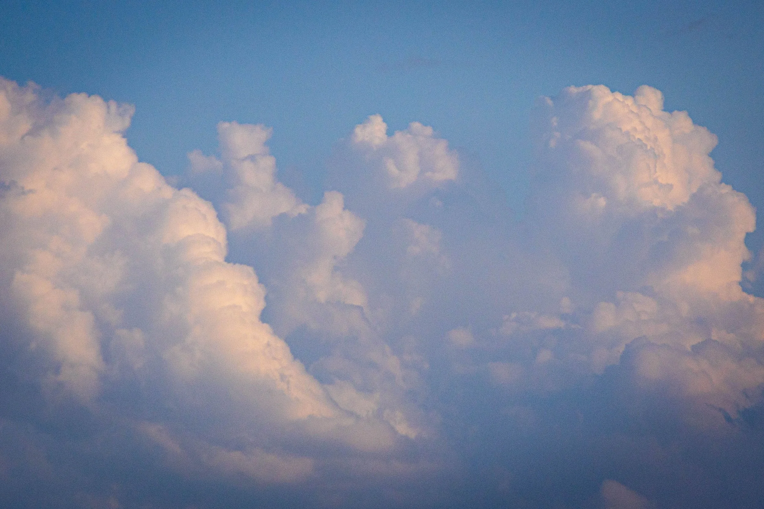 floating pink hued cloud in a blue sky representing mindfulness and emotions and feelings passing