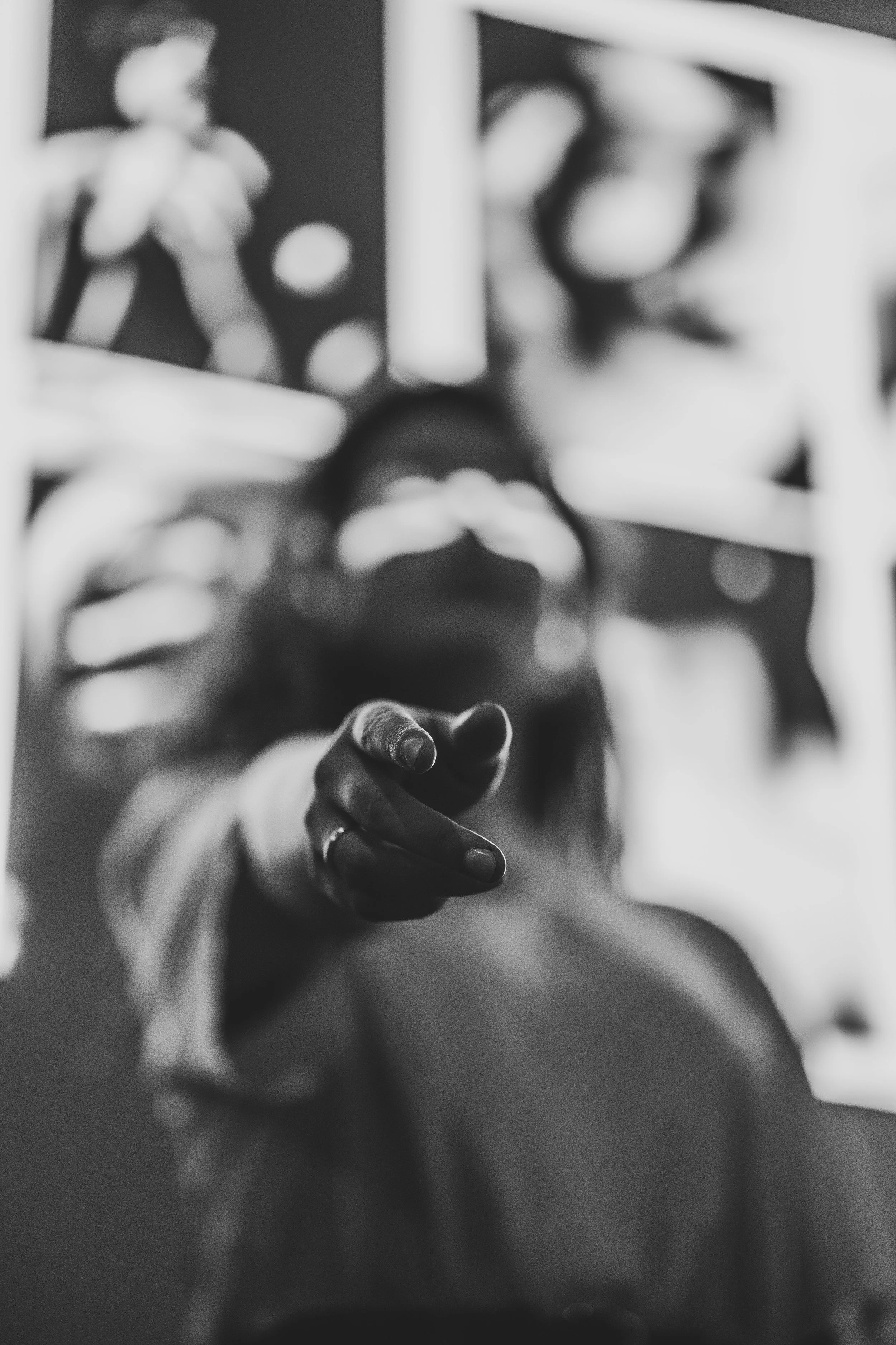 black and white photo of woman pointing into the camera representing sense of identity and confusion and ambiguity in understanding the self, finding purpose, and becoming on point