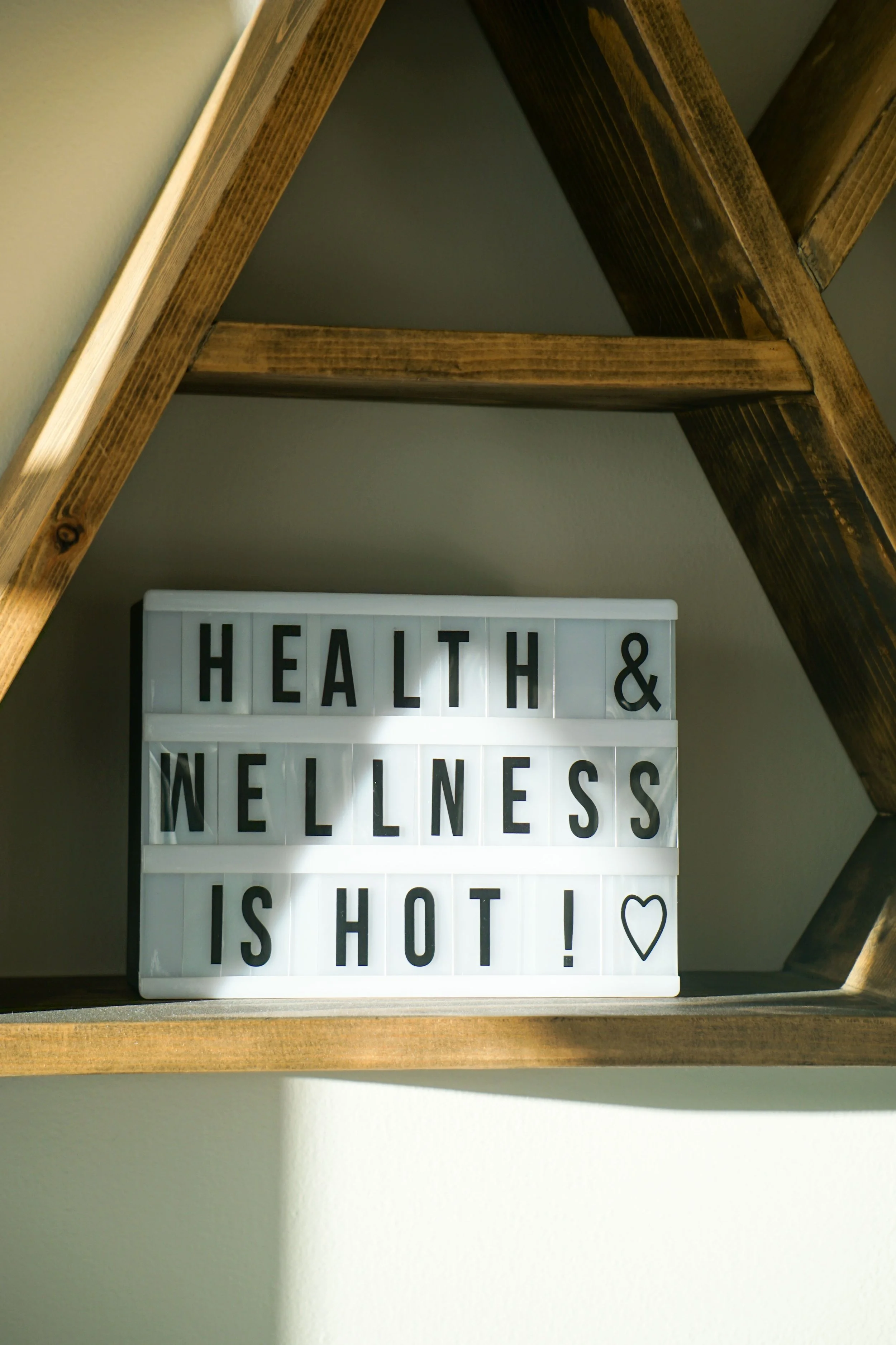 fitness sign stating health and wellness is hot sitting on a wooden shelf
