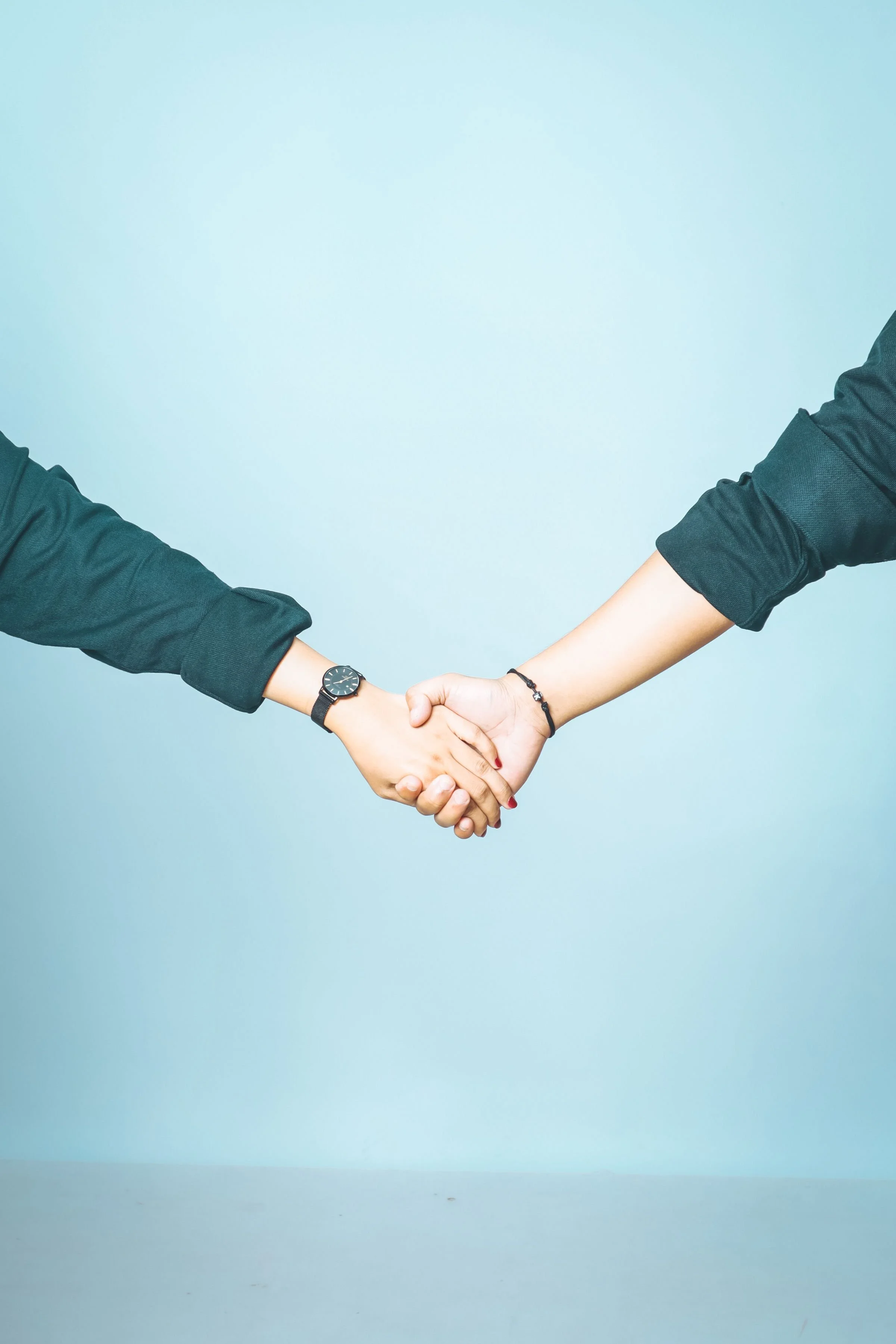 two people holding hands with minimalistic background representing relationship and attachment style