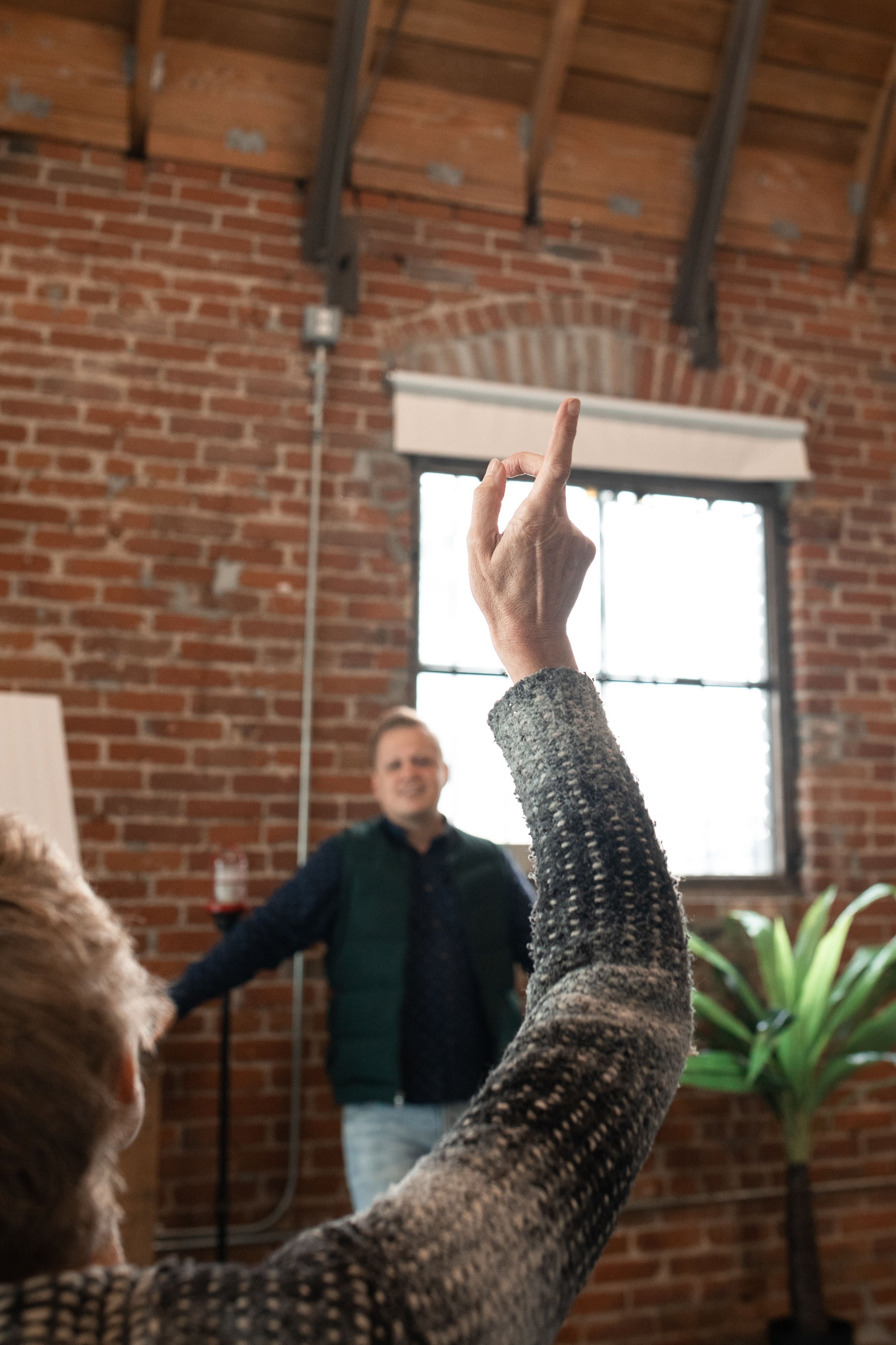 man raising hand to ask questions to self actualise and understand shadows in his psyche