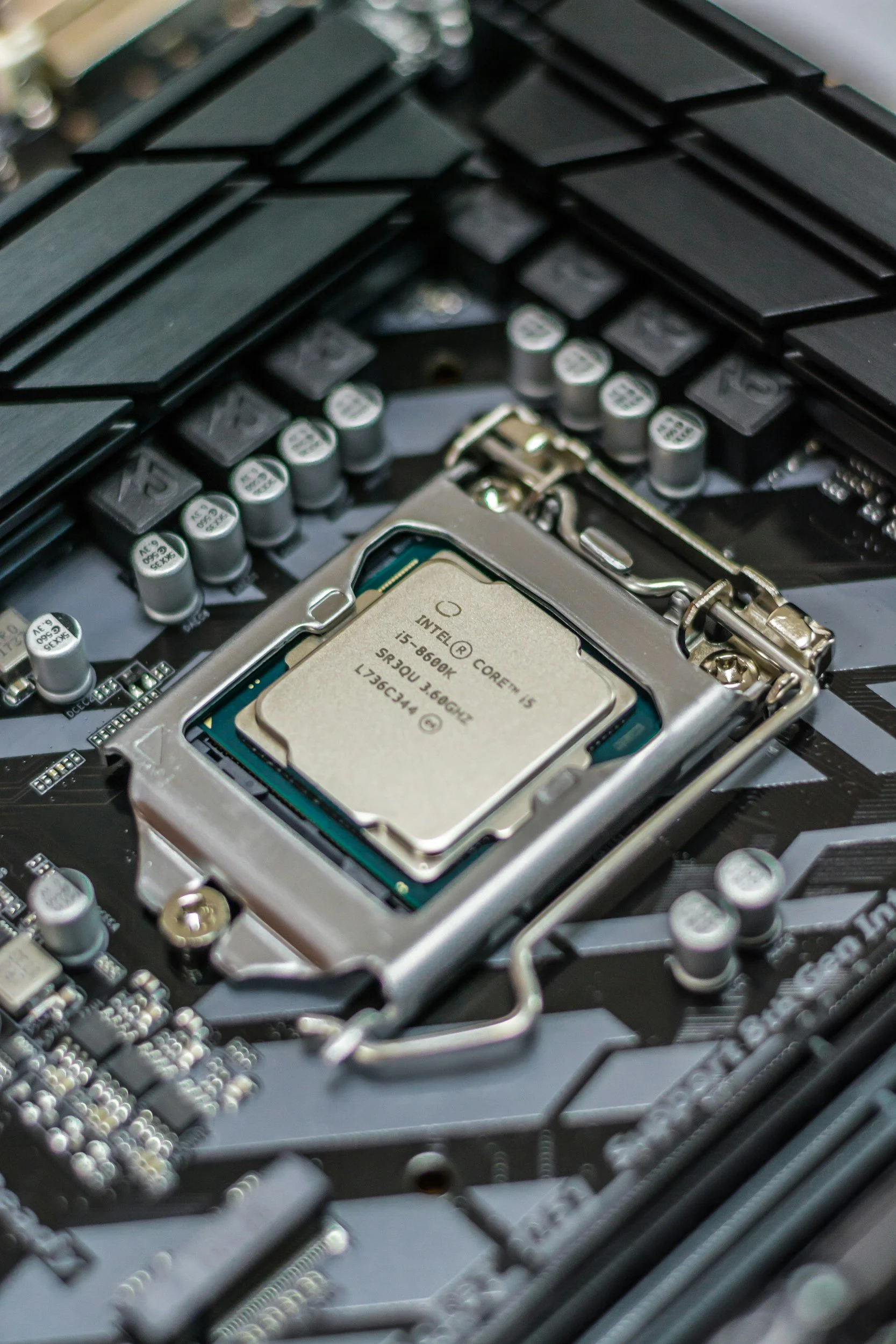 Close-up of an Intel processor installed on a computer motherboard surrounded by electronic components.