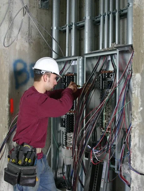 Electrician working at a commercial electrical panel