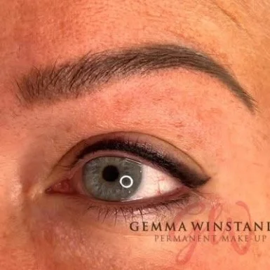 Close-up of a person's eye with makeup, including eyeliner and mascara, and the text "Gemma Winstanley Permanent Makeup" at the bottom right.
