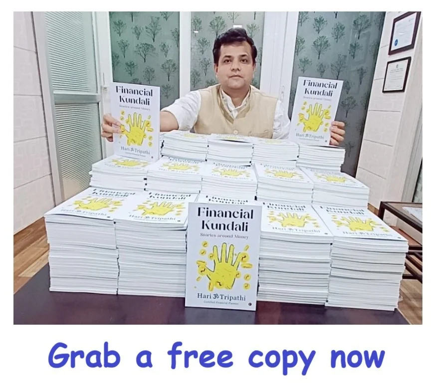 A man sitting behind a table with numerous copies of a book titled "Financial Kundali" by Hari Tripathi, holding one book in each hand. The background is decorated with a leafy pattern, and a sign on the table states "Financial Kundali" with a yellow hand illustration. The text at the bottom says "Grab a free copy now" in blue letters.