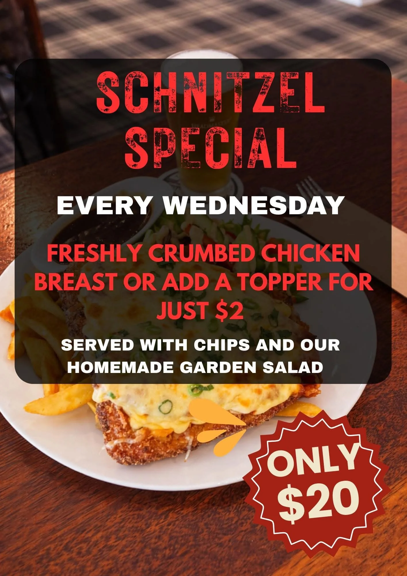 A pizza with melted cheese and green onions, French fries, a side of dipping sauce, a salad, a drink, and a promotional sign for a schnitzel special priced at $20.