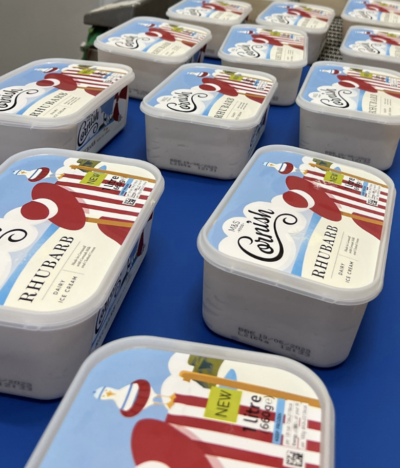 Multiple containers of Mrs. Courtney's Rhubarb dairy ice cream on a blue table.