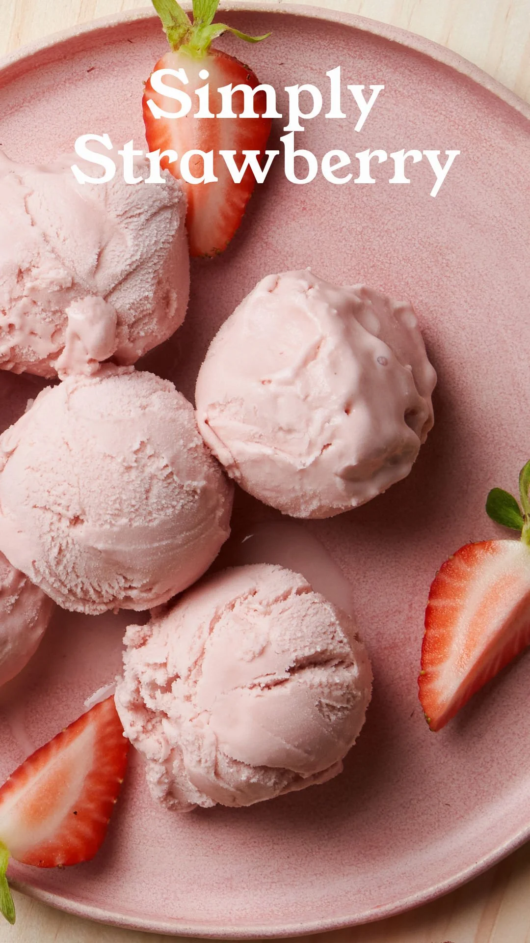 Pink ice cream scoops on a pink plate with sliced strawberries and the text 'Simply Strawberry' over the image.