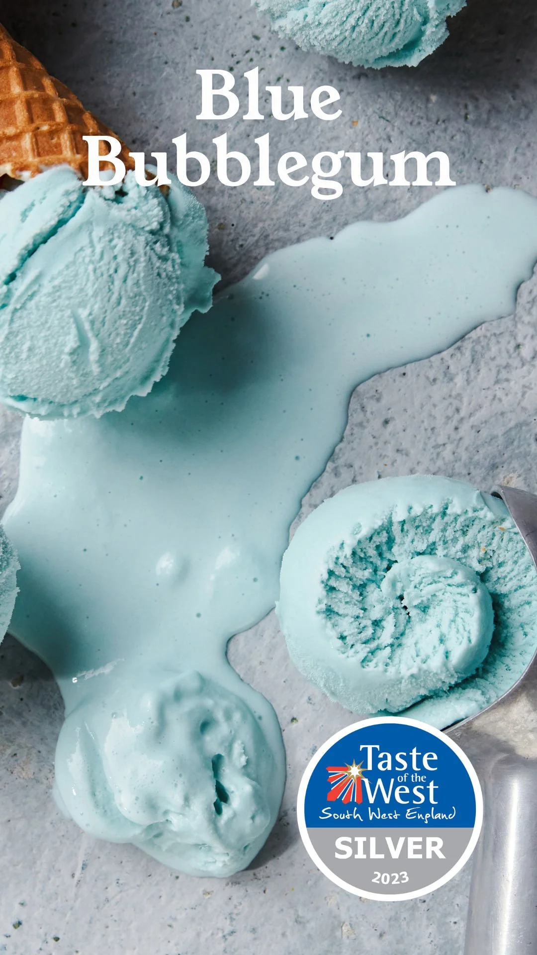 Ice cream scoops and a swirl of blue bubblegum flavored ice cream on a textured surface, with a spoon nearby. The image also features the text "Blue Bubblegum" and a logo indicating a silver award from Taste of the West.