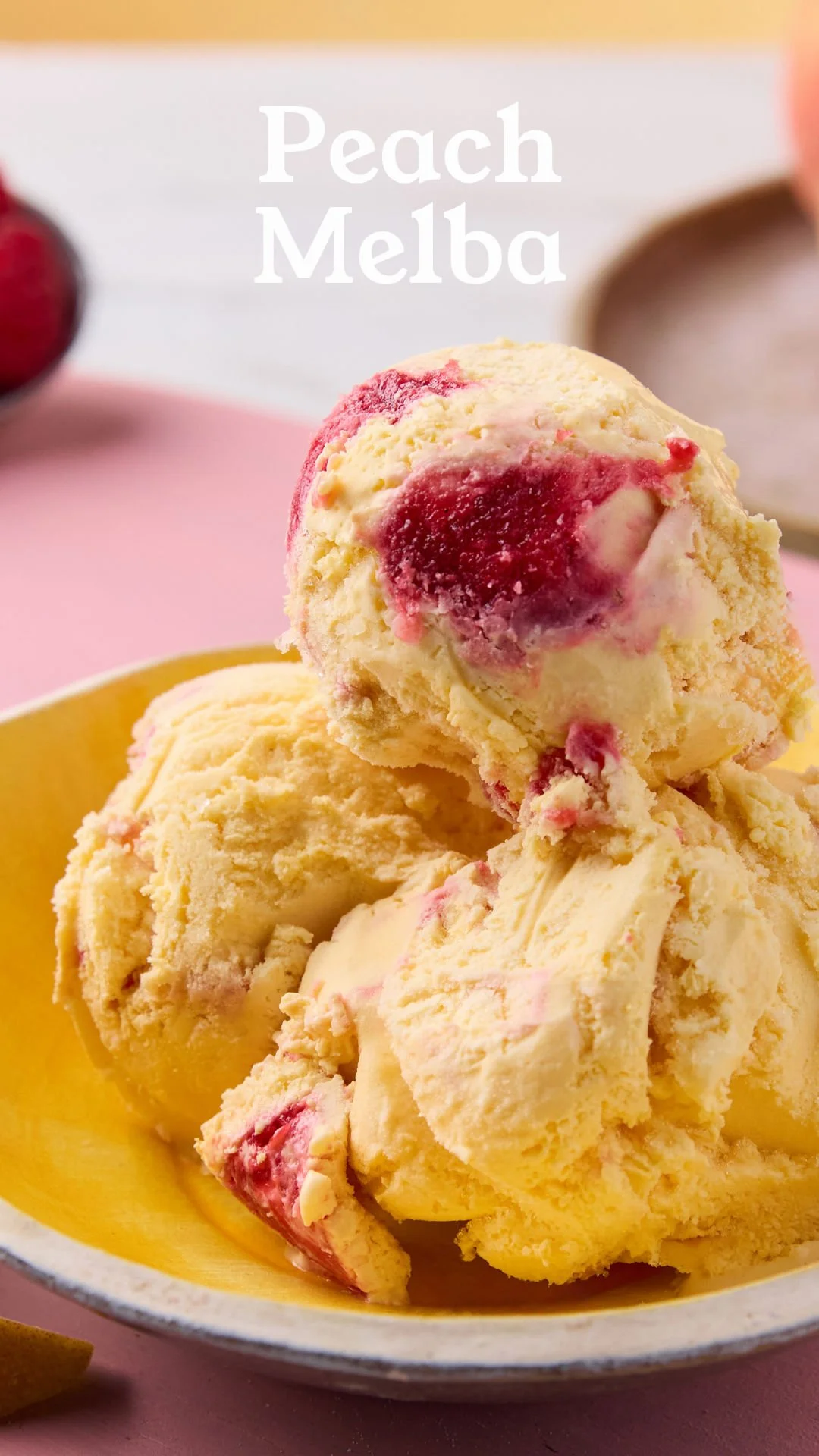 A bowl of peach melba ice cream with peach chunks and raspberry swirls.